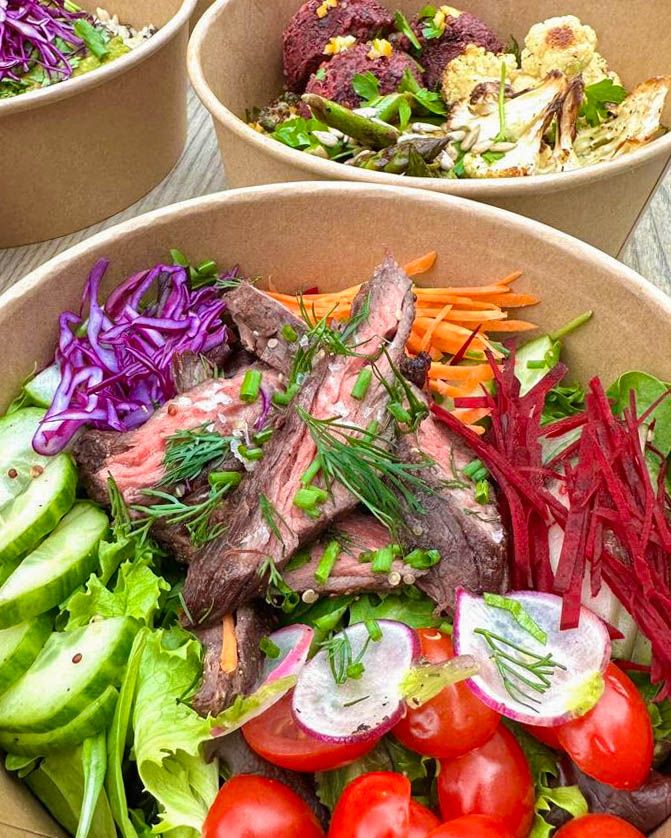 Catering steak salad bowl with fresh vegetables, radishes, cherry tomatoes, and herbs.
