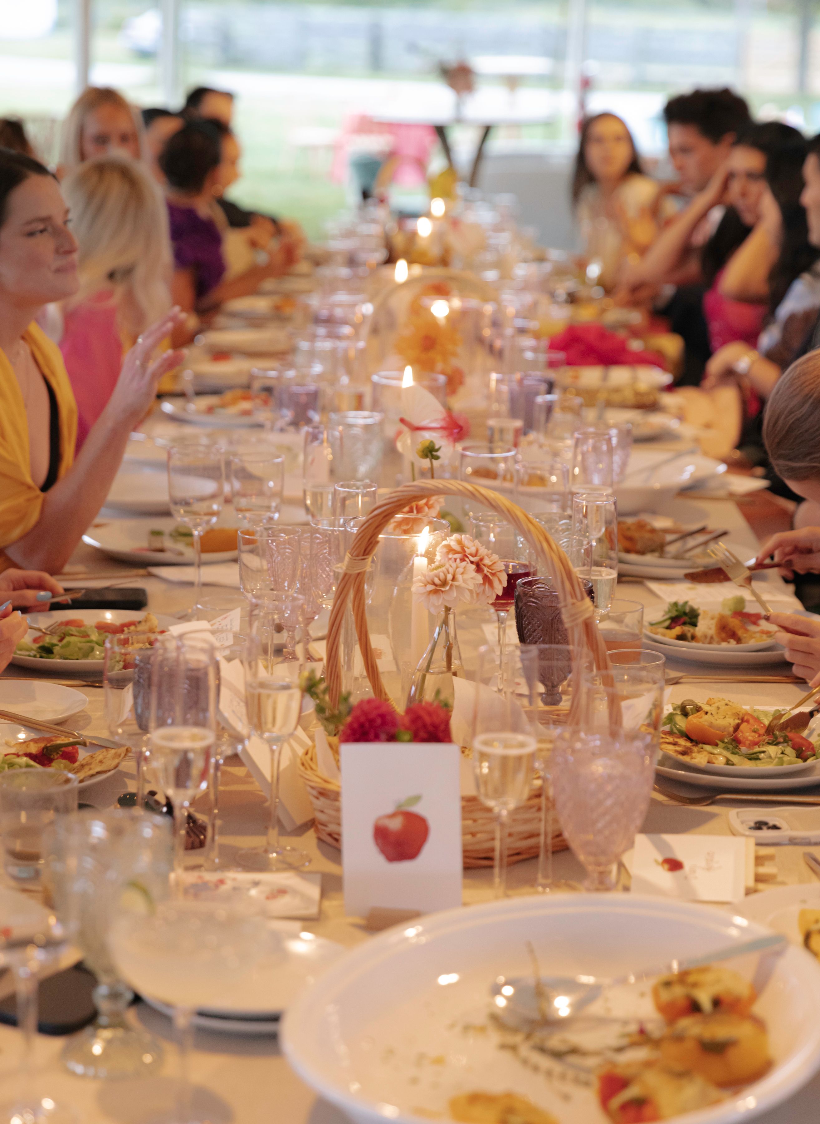 Elegant long table wedding dinner with guests enjoying plated dishes and full-service catering setup