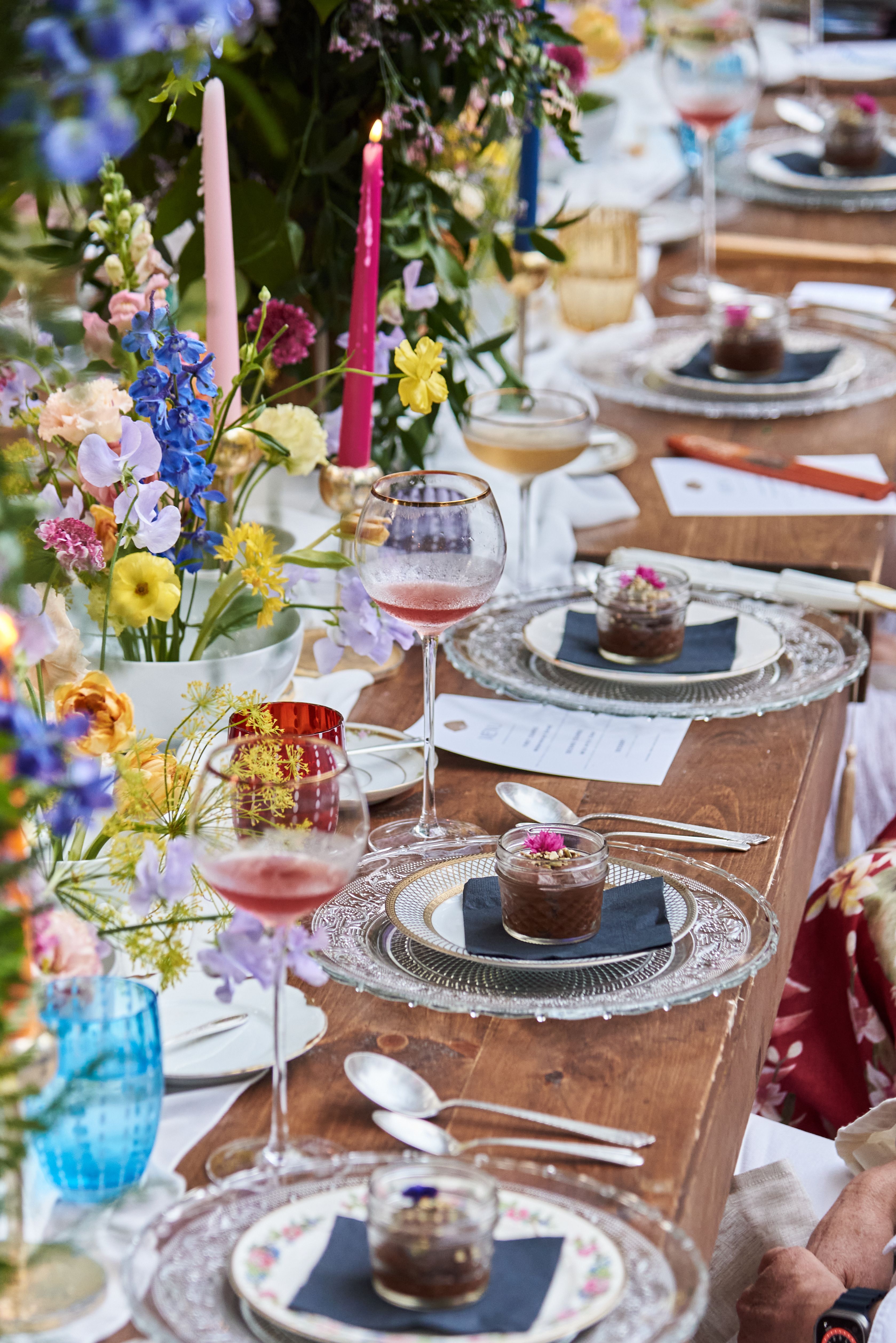Vibrant floral tablescape with plated dishes and drinks at a styled catered event