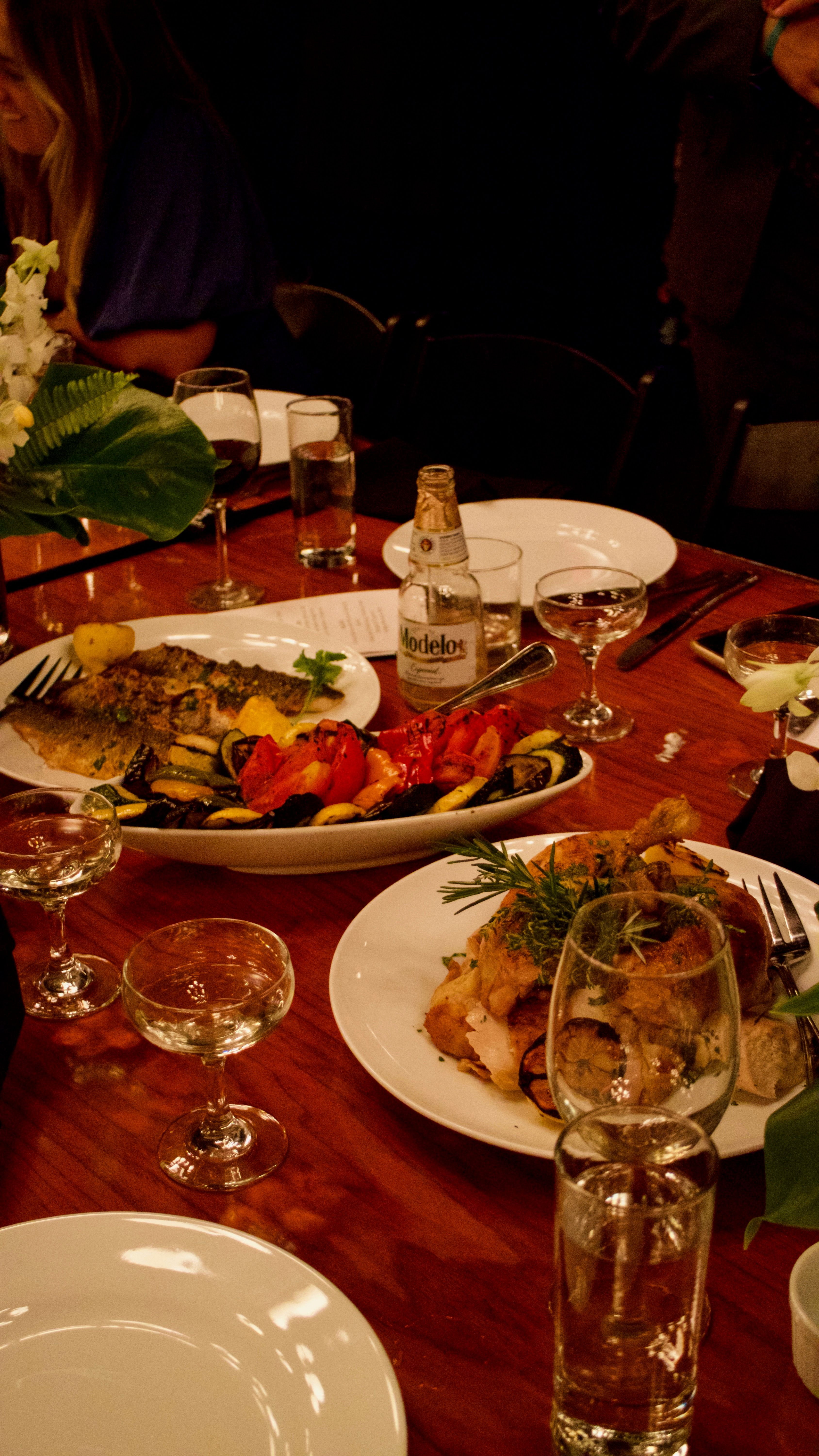 Social event catering with roasted chicken, vegetables, and shared platters at an elegant event.