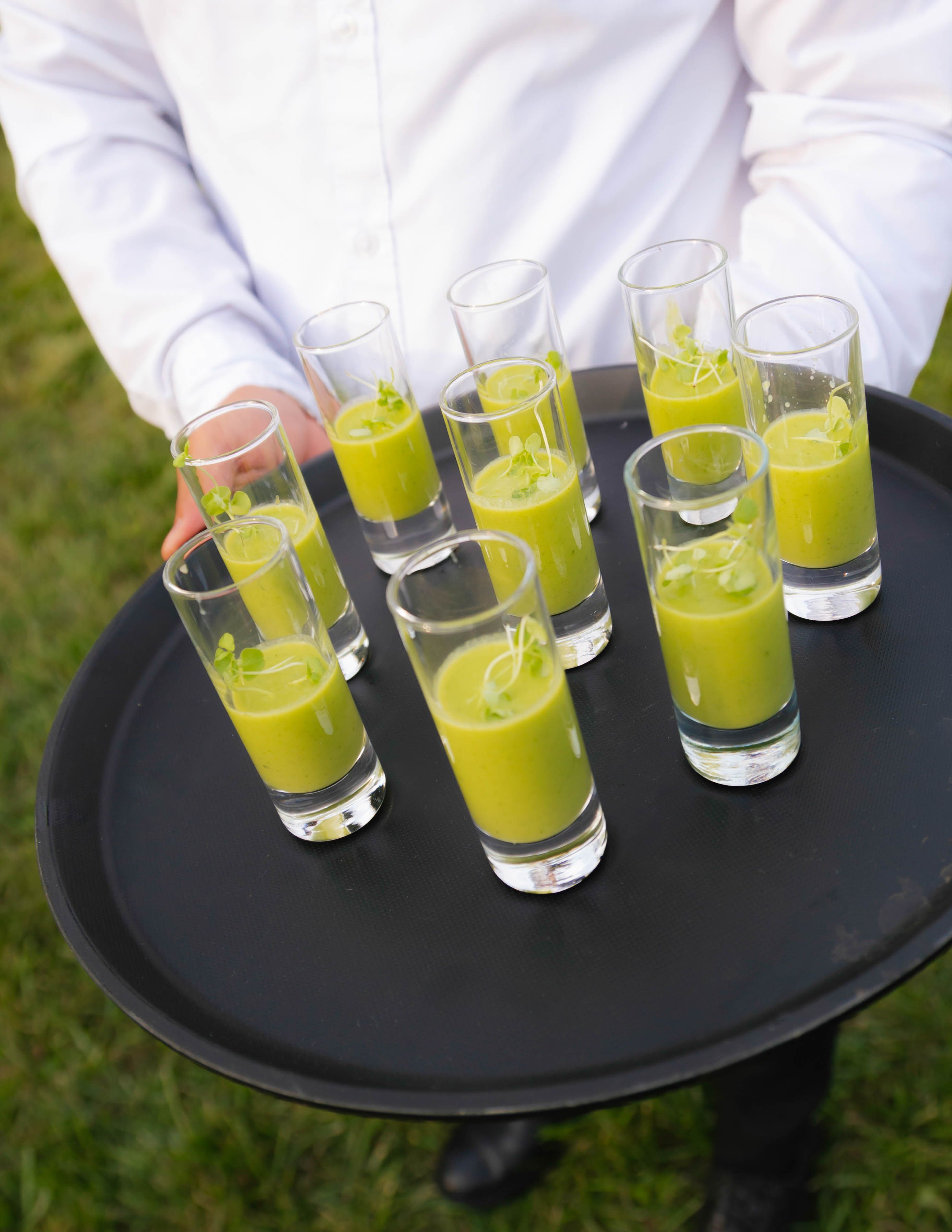 Green vegetable shooter appetizers served during wedding cocktail hour catering.