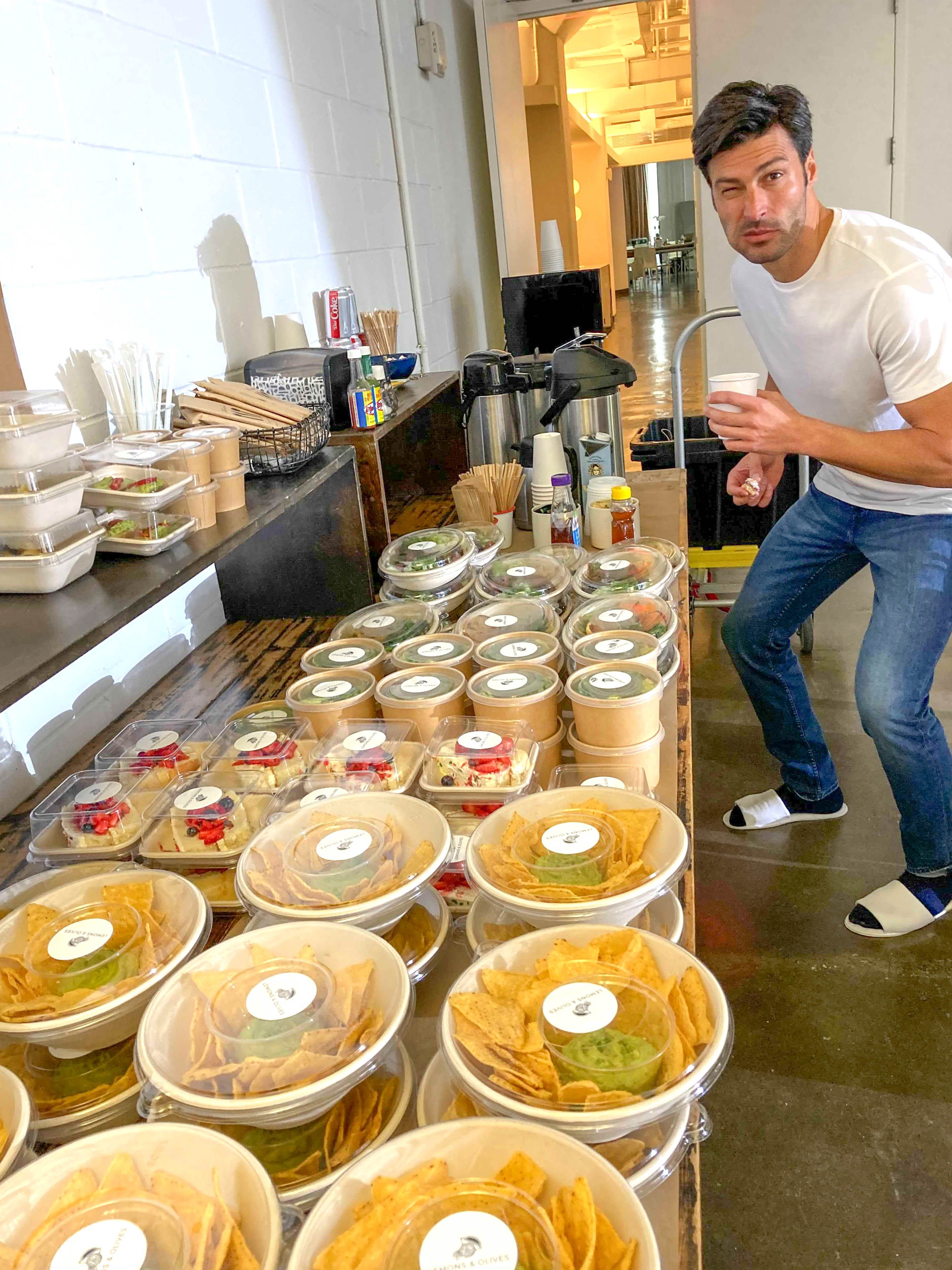 Catering team preparing packaged meals and snack bowls for event service.