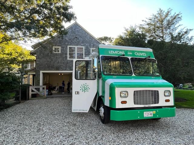 Guests mingling during an outdoor wedding cocktail hour with elegant catering setup and seating.