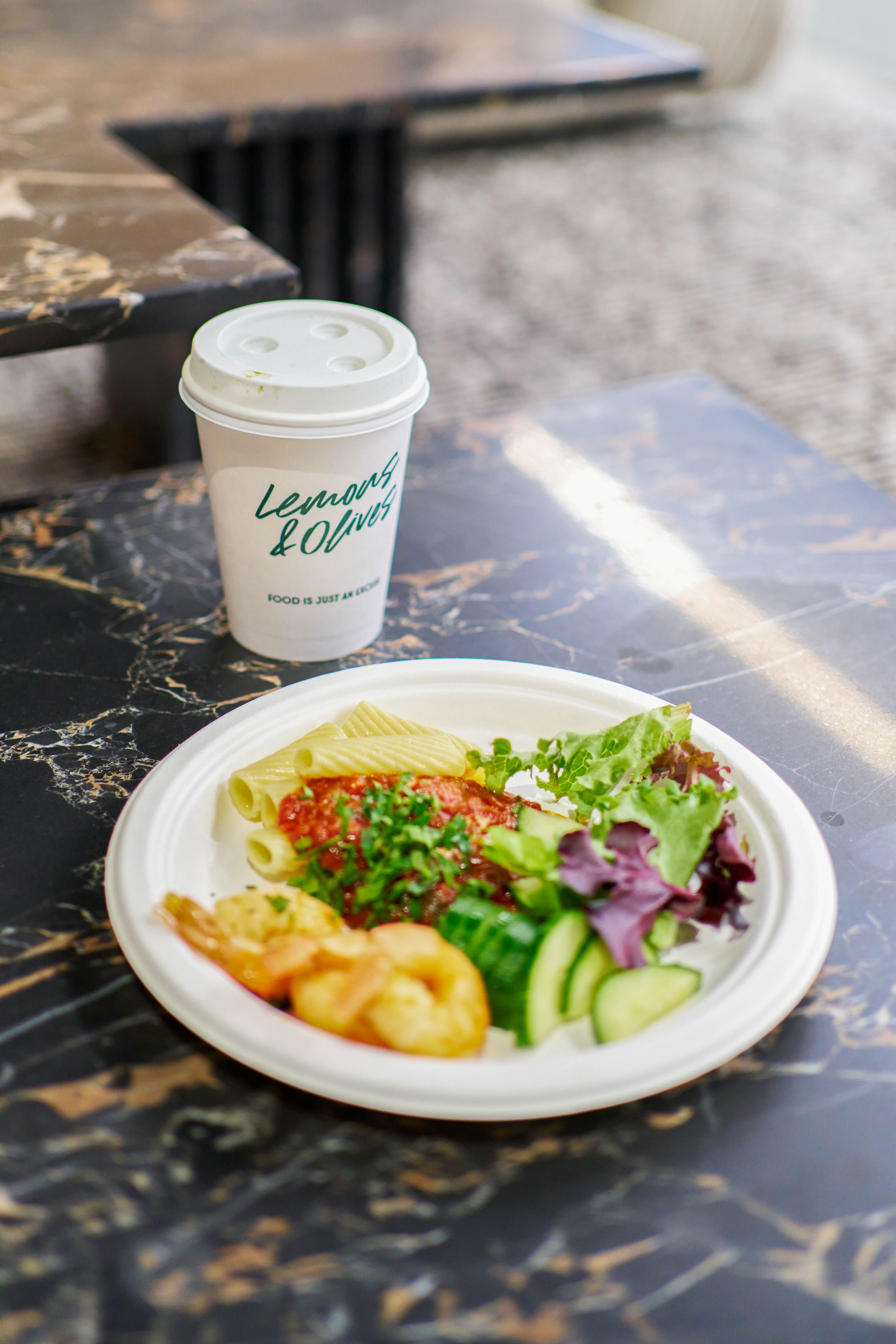 Coffee and refreshment station at a catered event with branded Lemons and Olives cup.
