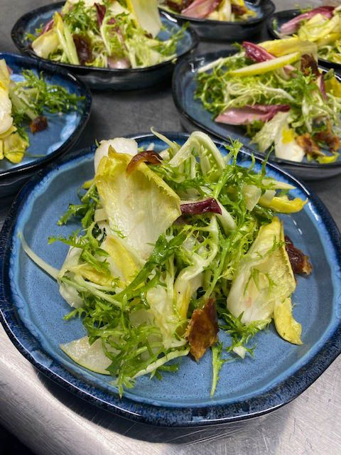 Plated gourmet salad course prepared for a catered event service.