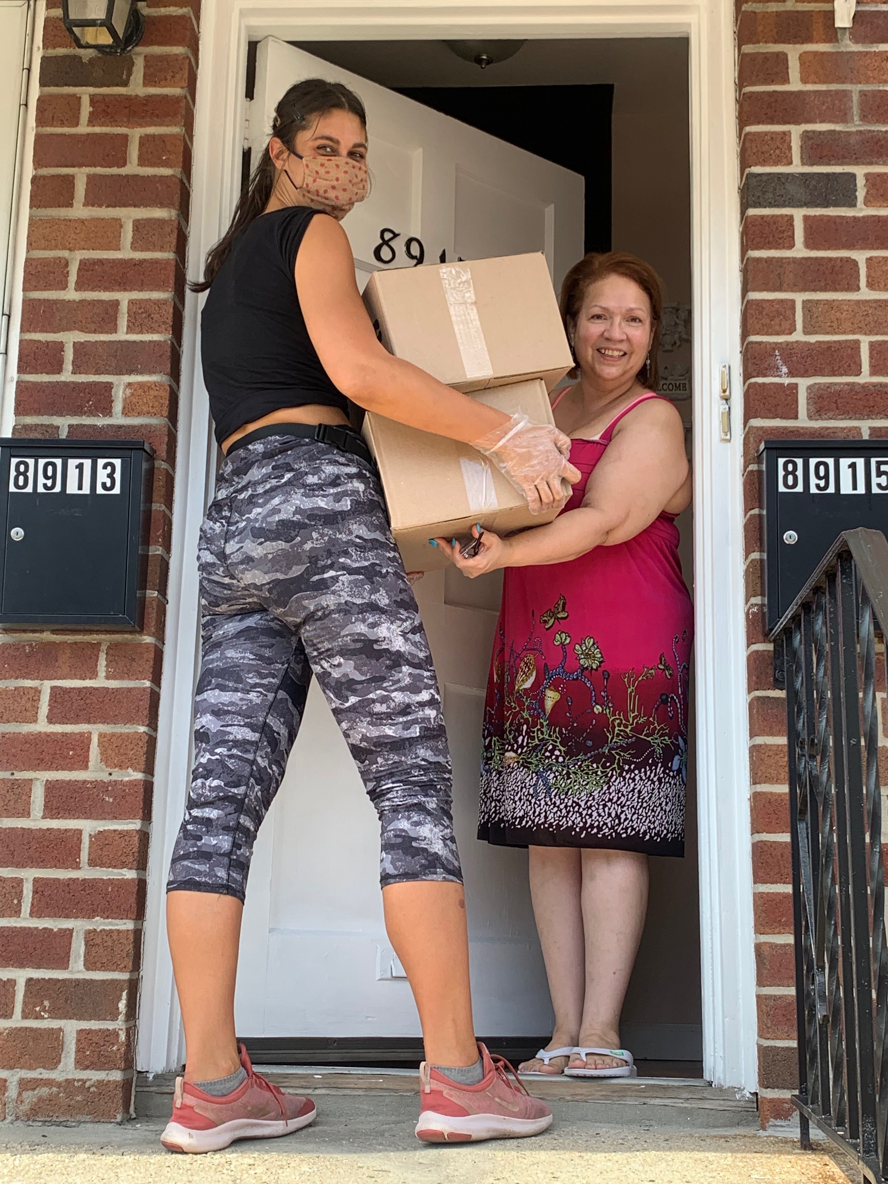 Emergency meal delivery being handed to a resident at their front door.