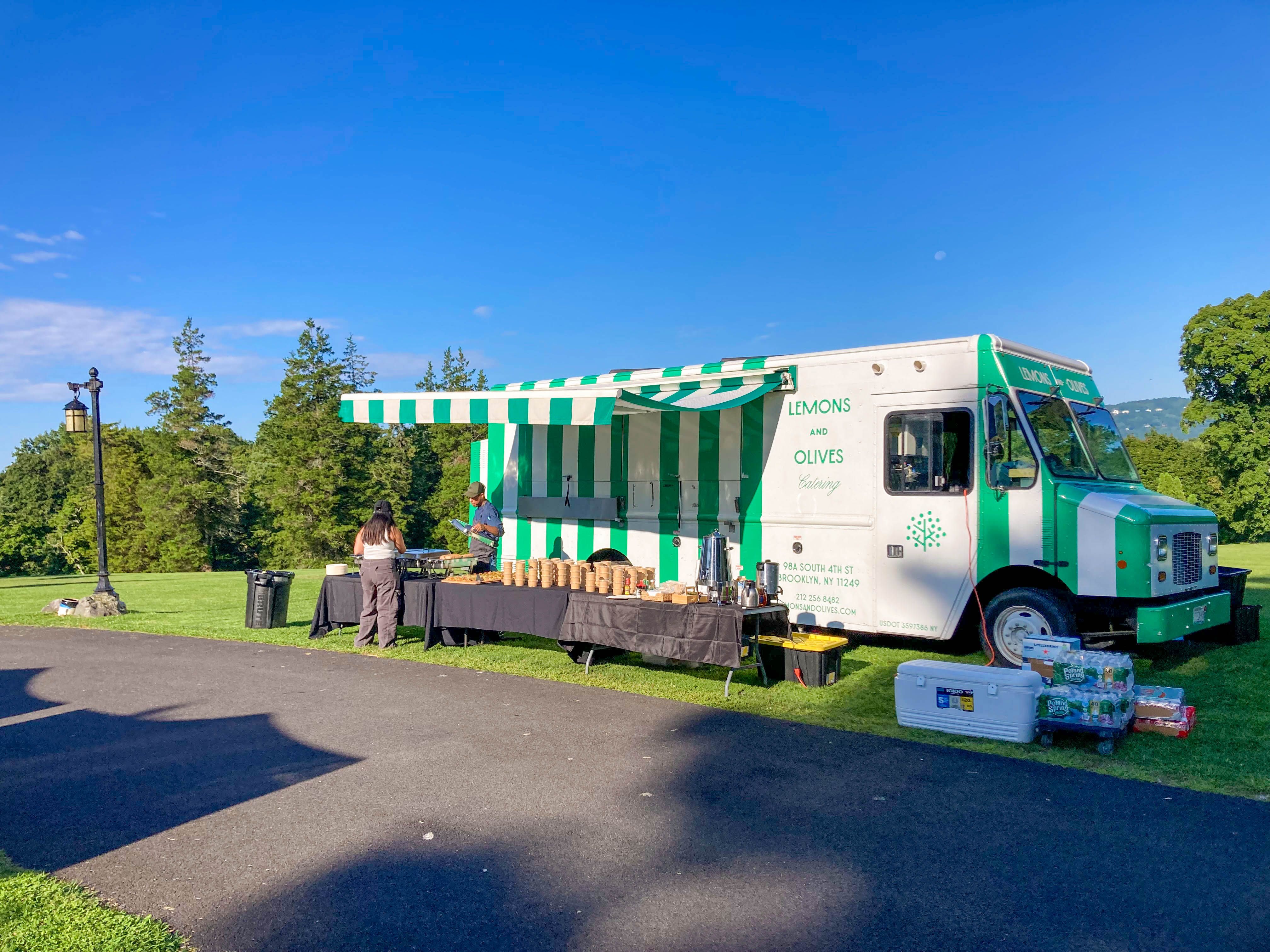 Lemons and Olives catering food truck set up for an outdoor event with service tables.