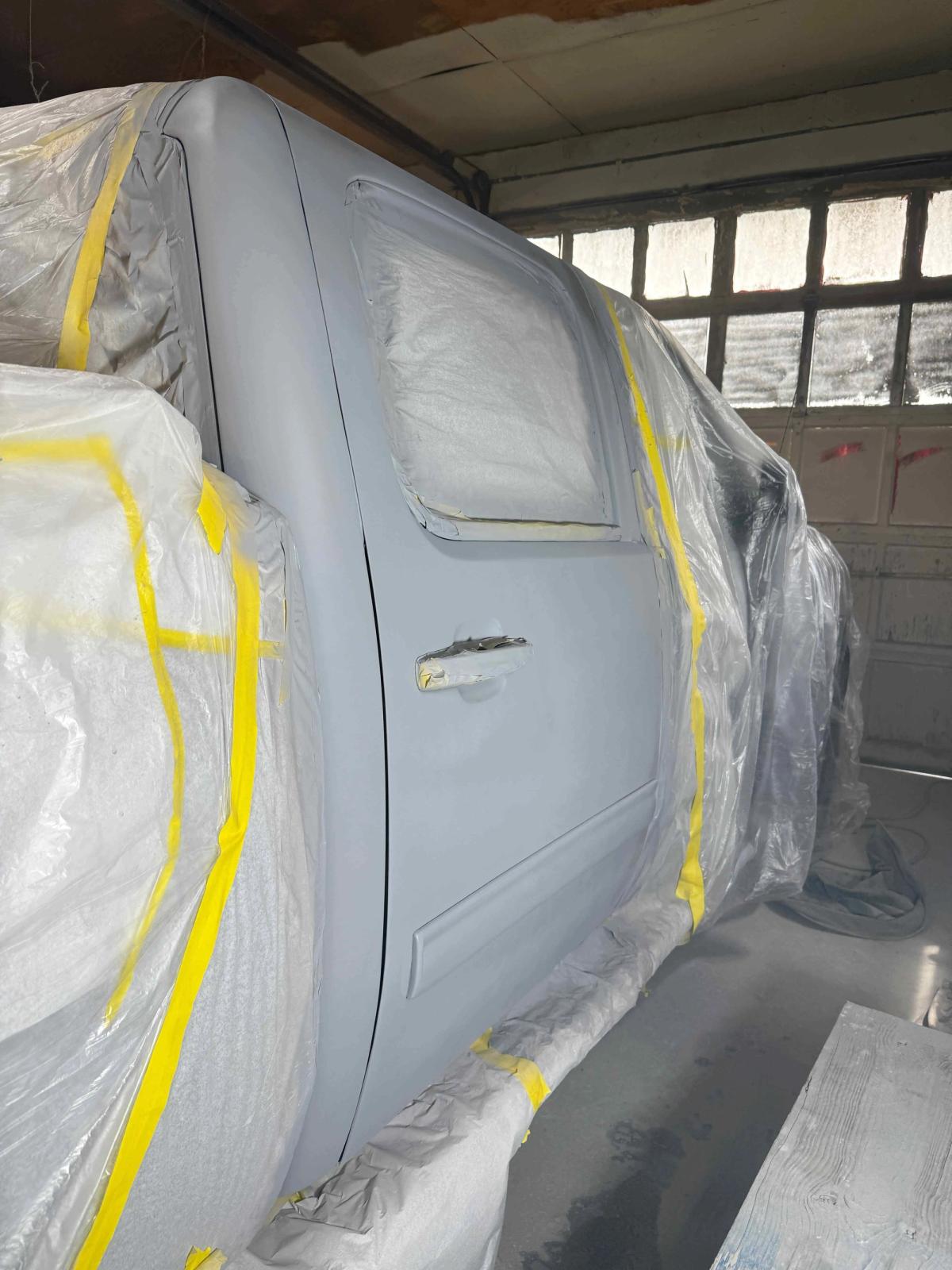 Truck door with scraped and faded paint before refinishing work