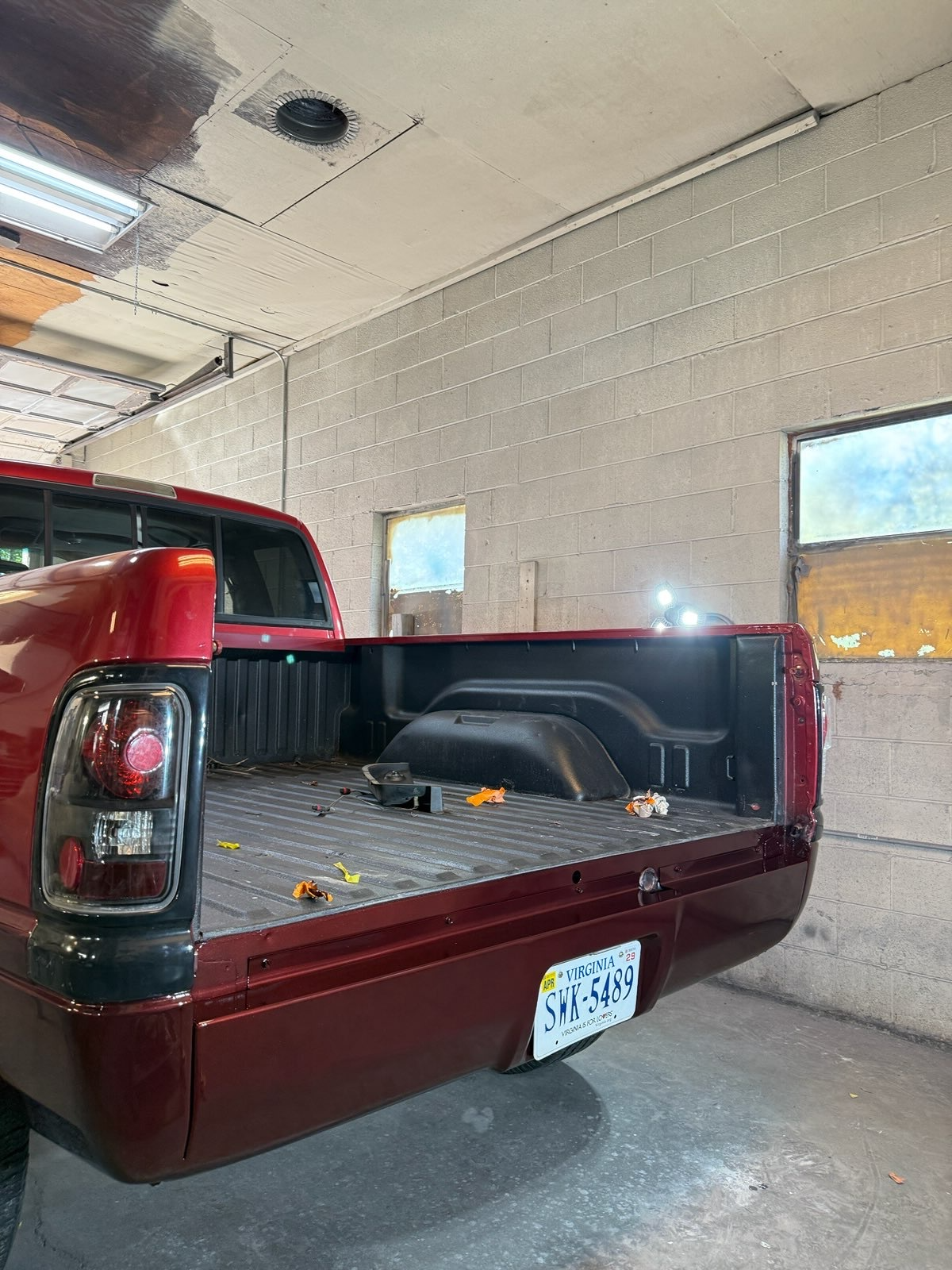 Refinished red pickup bed with glossy paint and restored rear body panels inside the shop