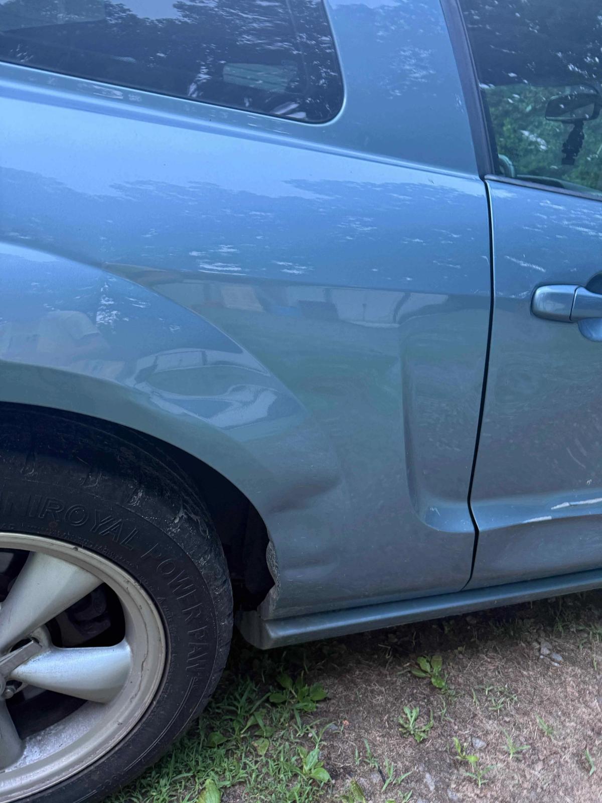 Creased fender with dent damage before auto body repair in Central Virginia