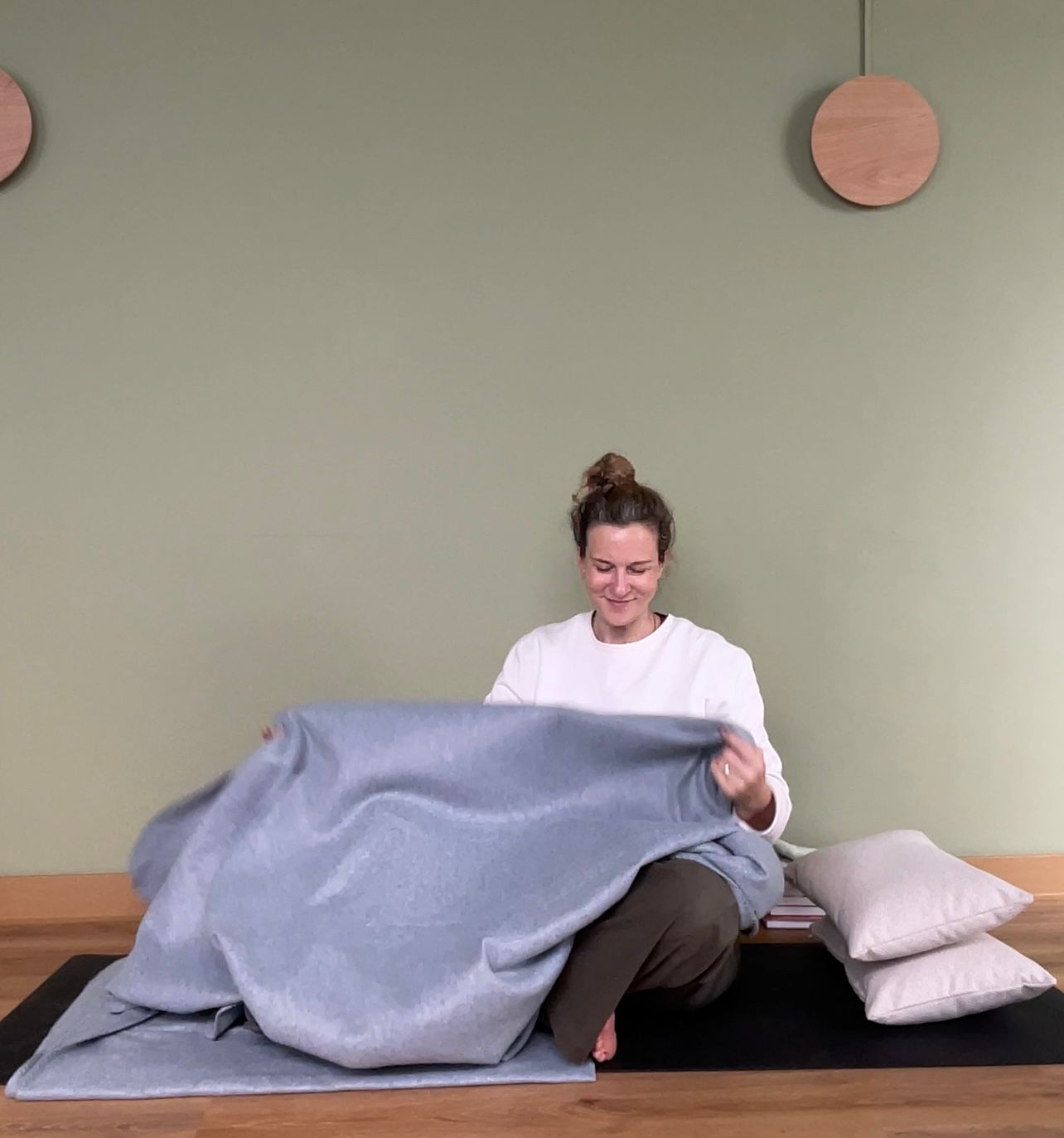 a therapist's hands resting on a client's back during a quiet 1:1 session.