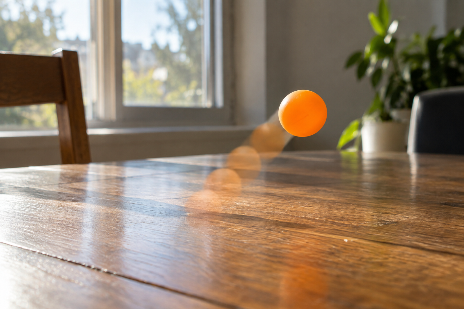 An orange ping-pong ball frozen mid-bounce on a wooden table