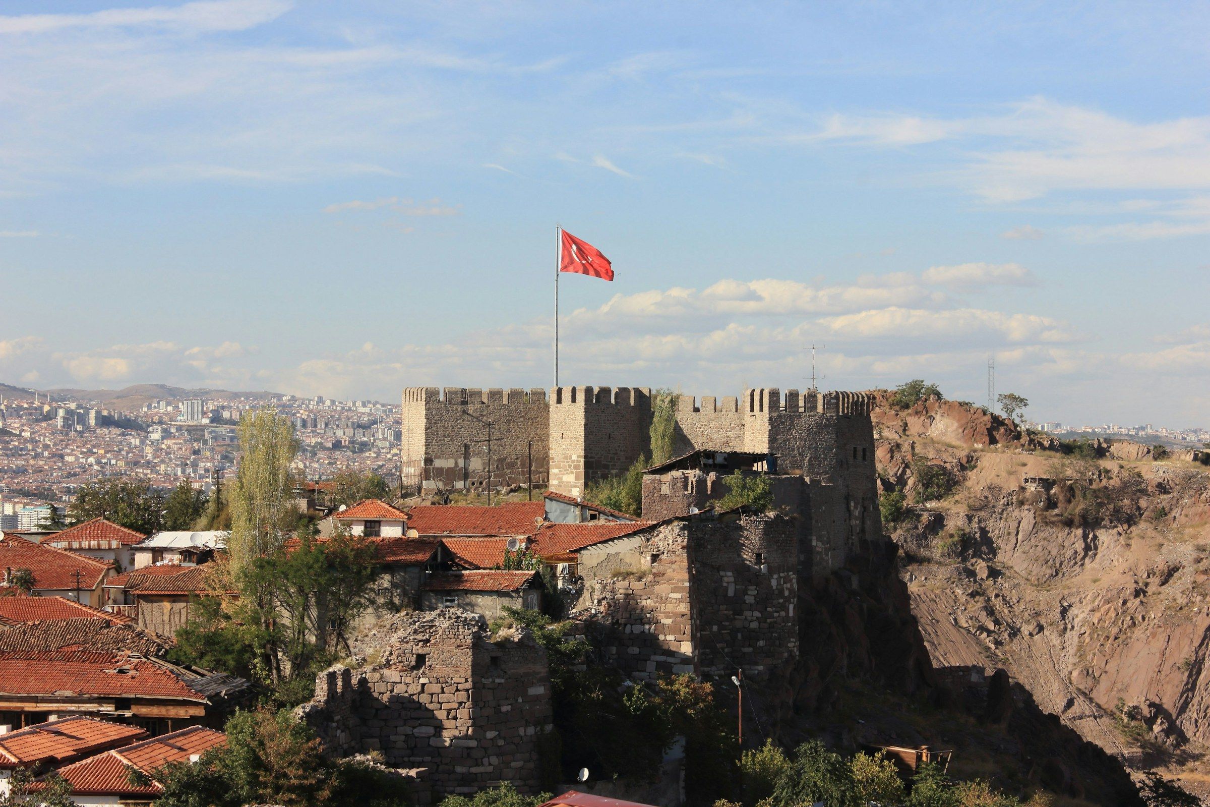 Ankara Kalesi, burcunda dalgalanan Türk bayrağı ve arkasında şehir