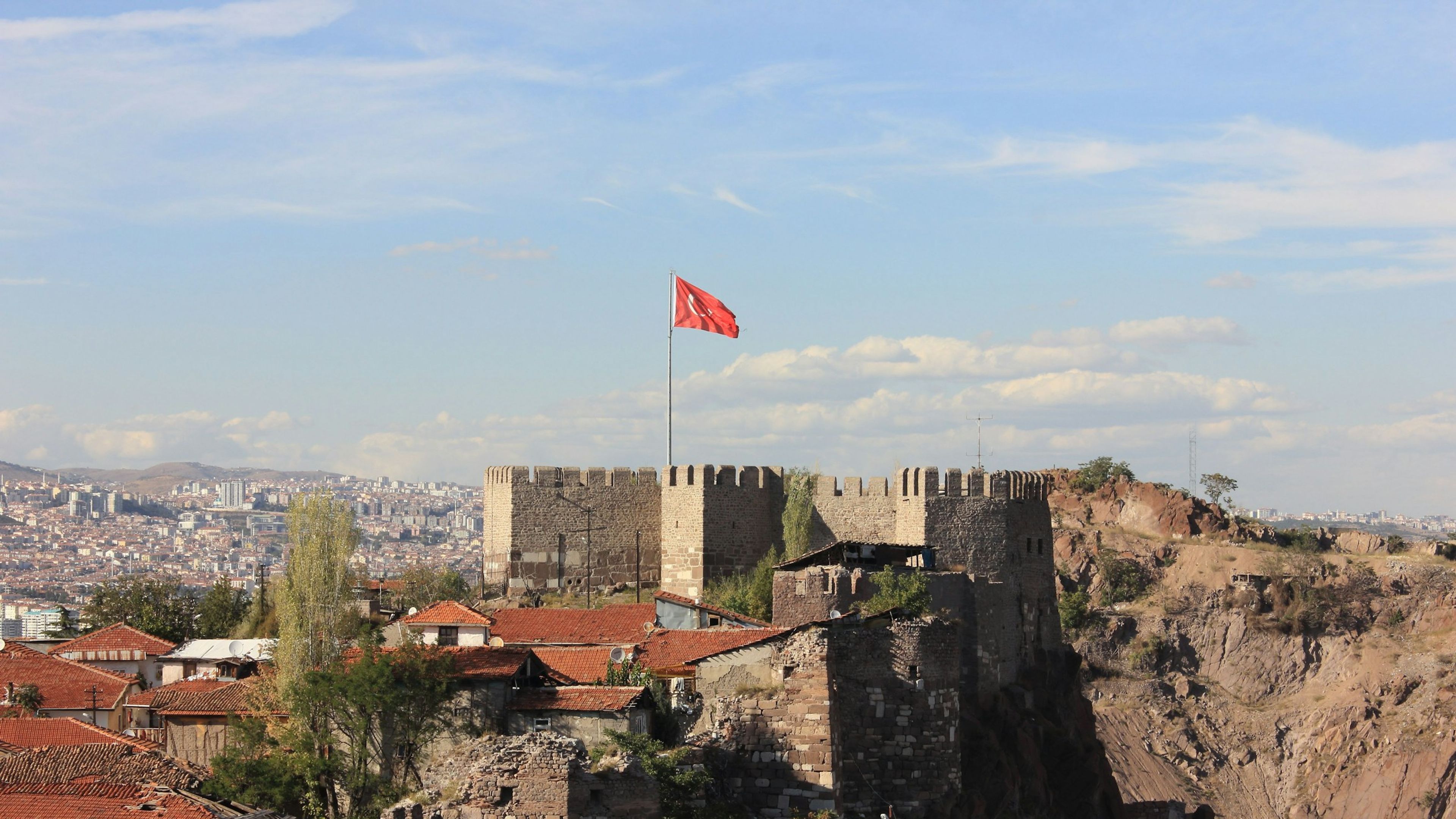 Ankara Kalesi, burcunda dalgalanan Türk bayrağı ve arkasında şehir