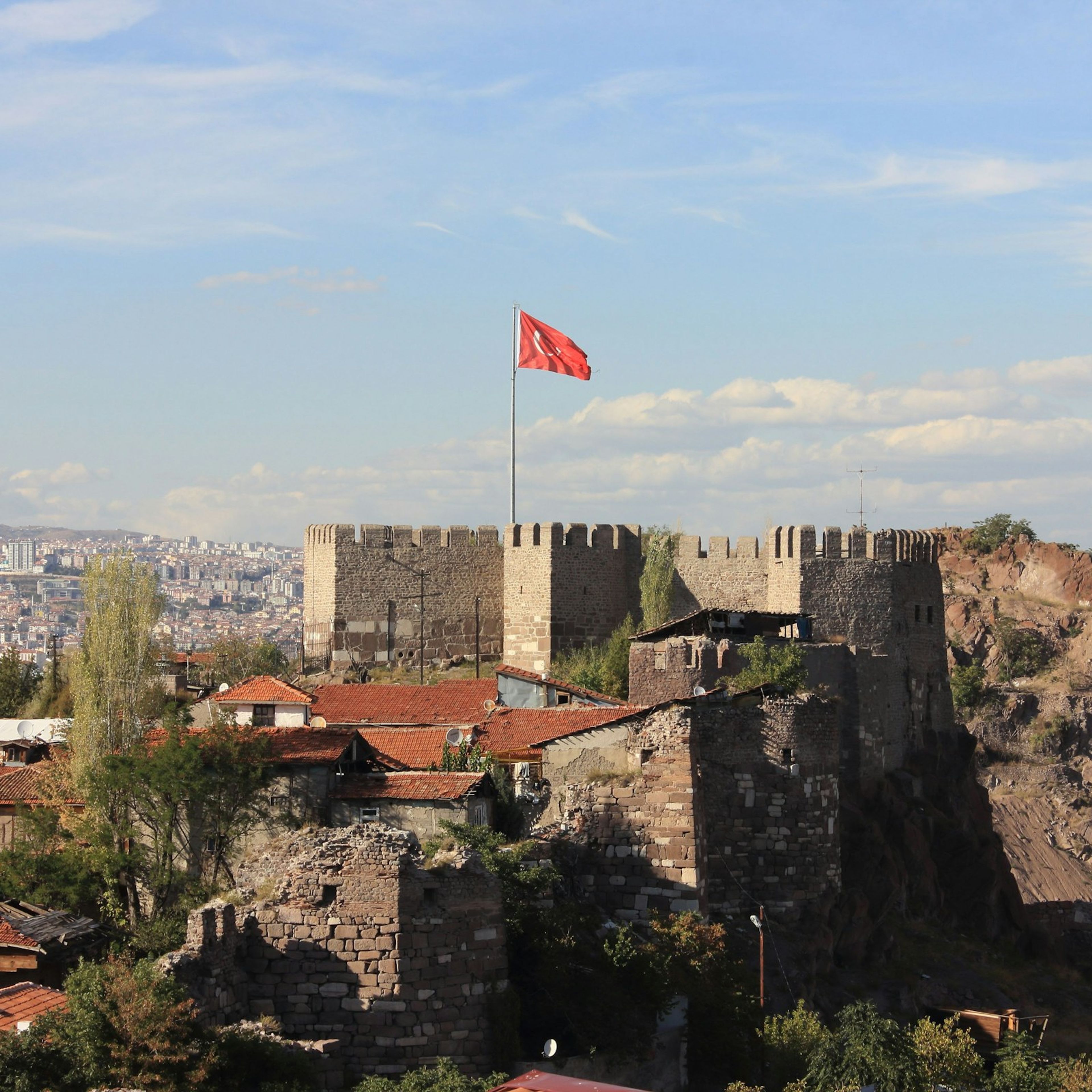 Ankara Kalesi, burcunda dalgalanan Türk bayrağı ve arkasında şehir