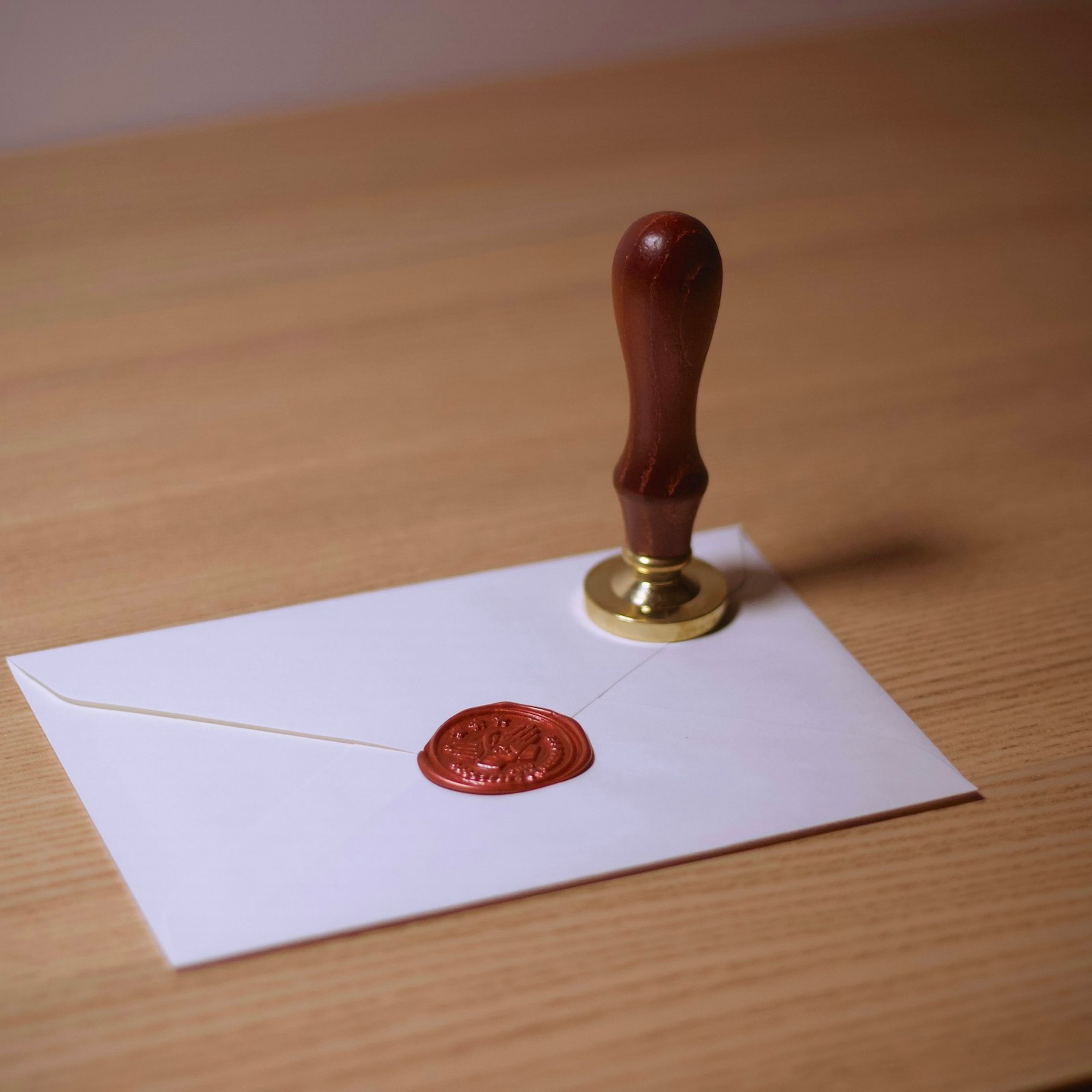 Mühürlenmiş bir zarf ve yanında ahşap saplı mühür