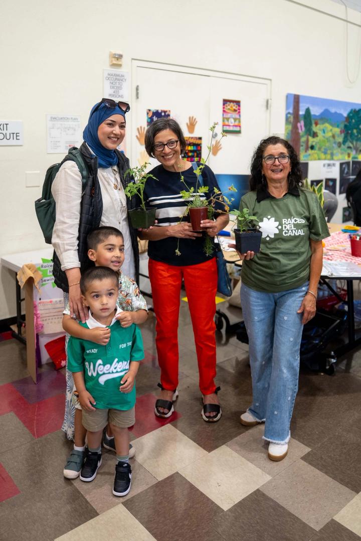 Children and adults gathered with potted plants at a community event