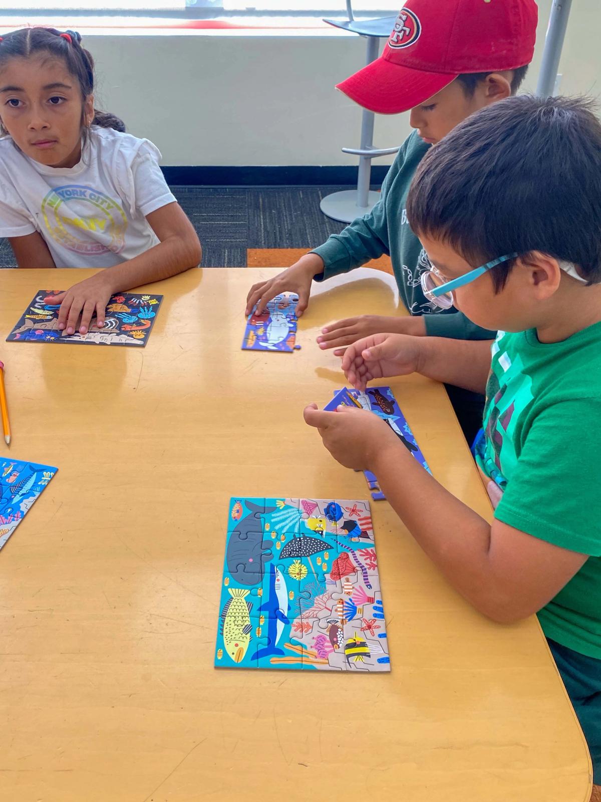Students working on colorful puzzles at a classroom table