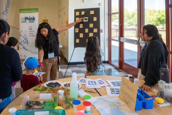 Young people sharing an exhibit with visitors at Green Fest