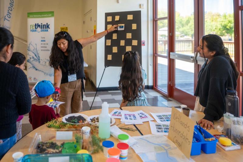 Young people sharing an exhibit with visitors at Green Fest