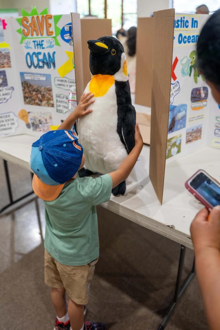 A young person sharing a handmade exhibit with Green Fest visitors