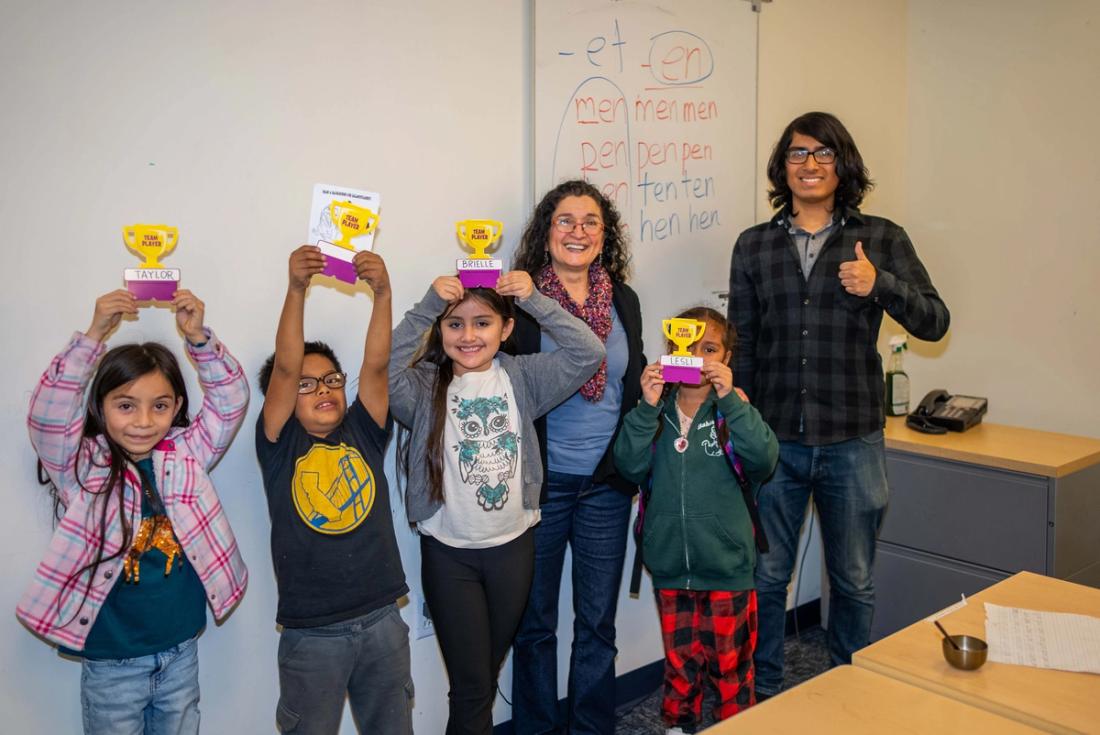 Children and adults holding up colorful handmade paper projects