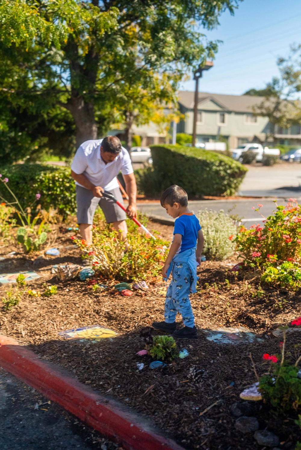 An adult and a child caring for a planted neighborhood space