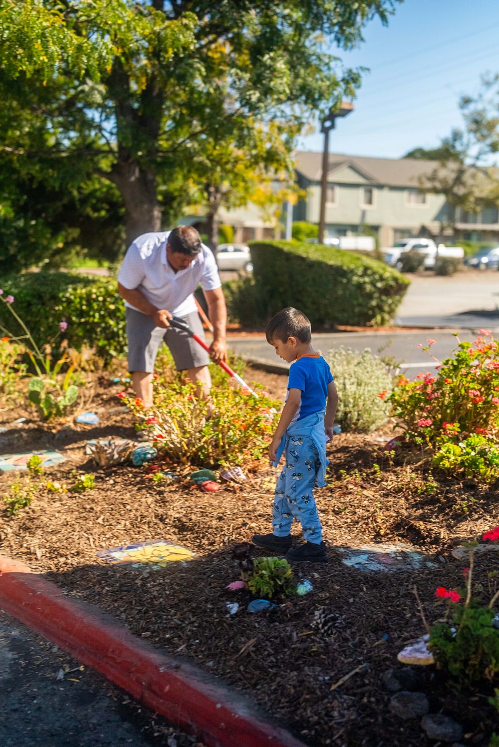 An adult and a child caring for a planted neighborhood space