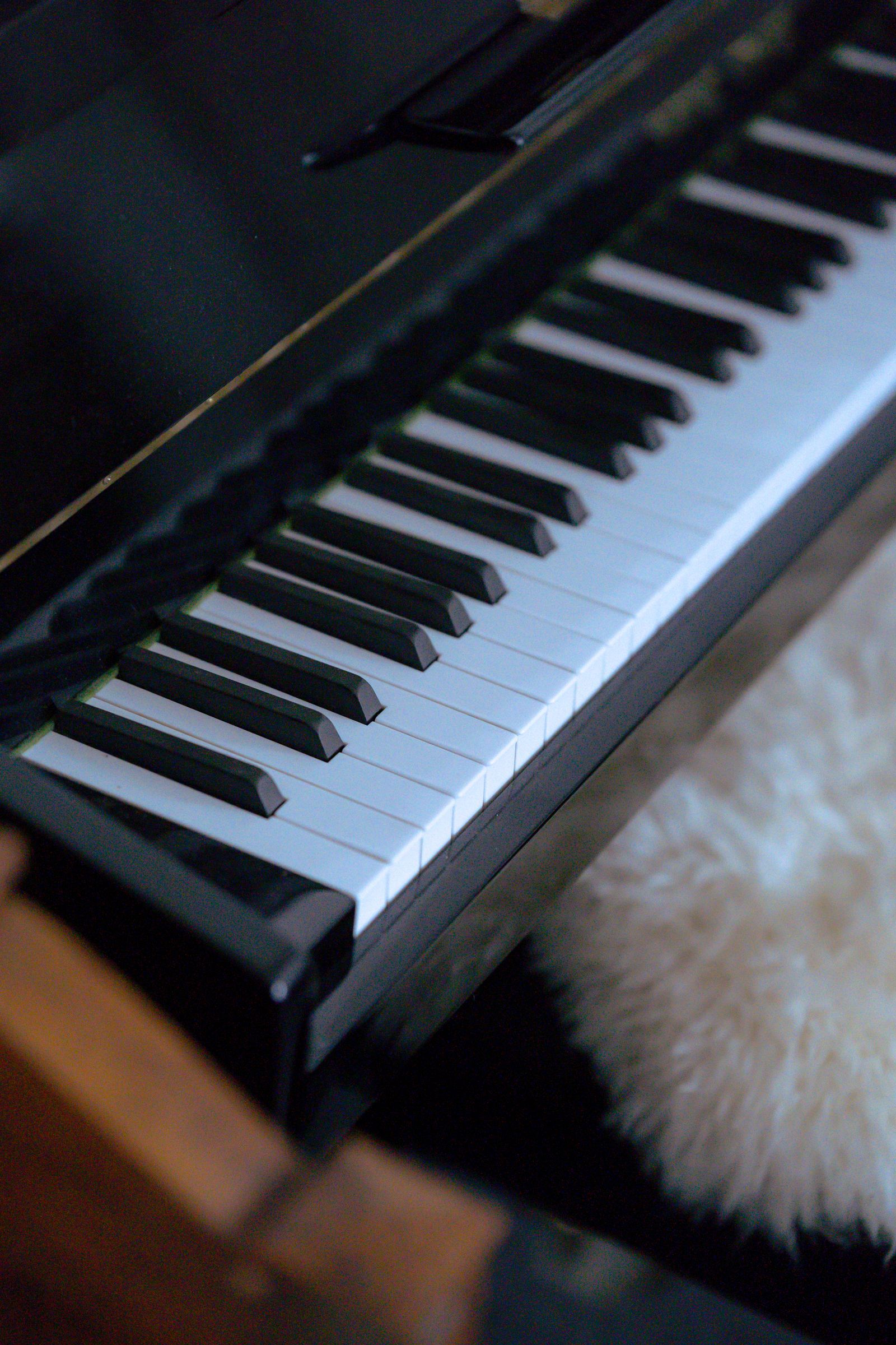 Gros plan sur le clavier d'un piano à queue noir, vu de biais