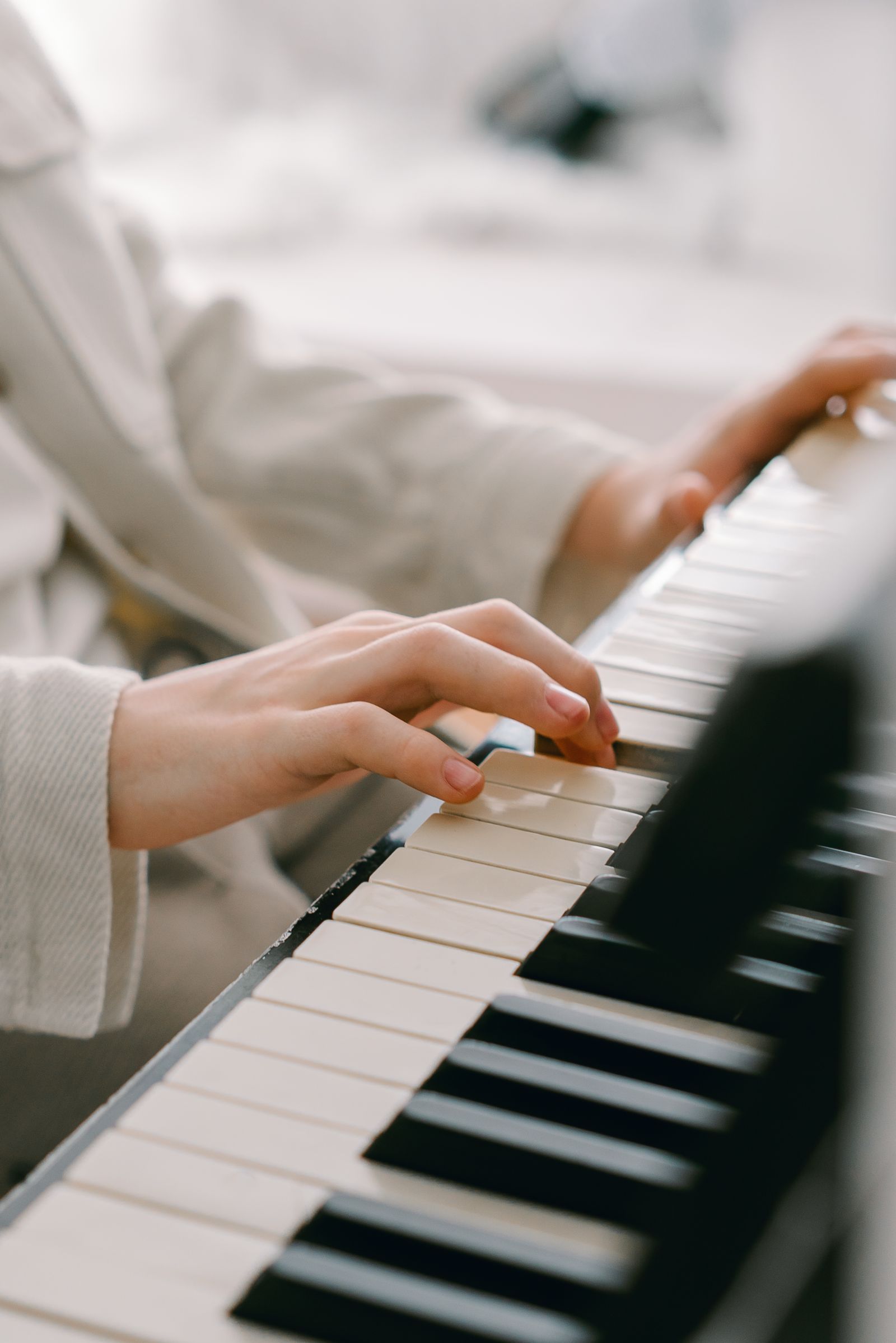 Mains jouant sur un piano numérique, vue lumineuse