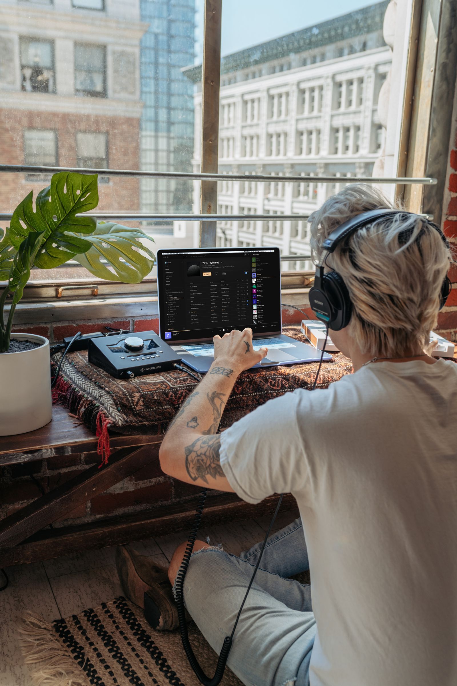 Personne au casque devant un ordinateur portable avec une interface audio