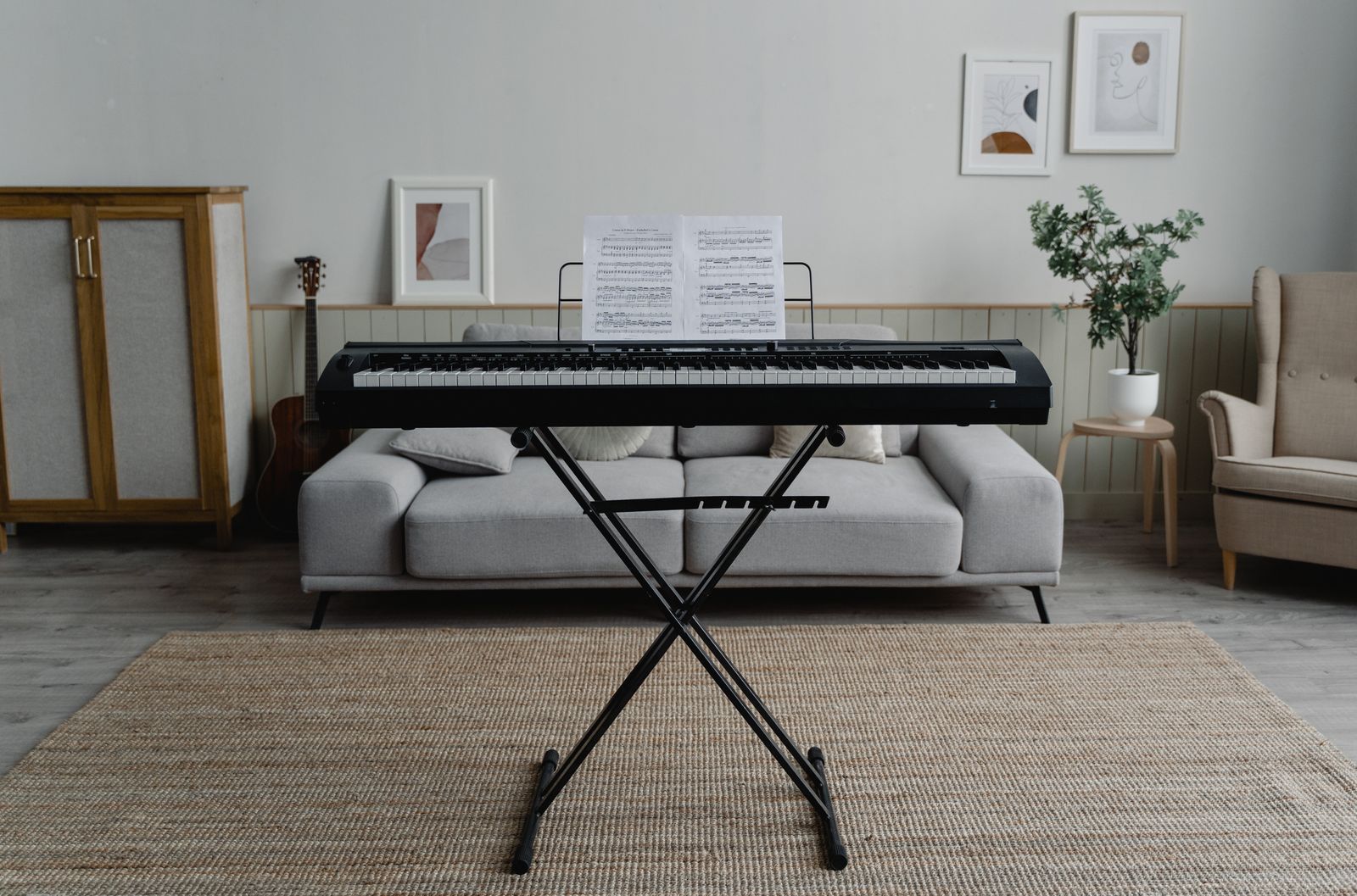 Piano numérique portable posé sur un stand en X dans un salon, prêt à être transporté