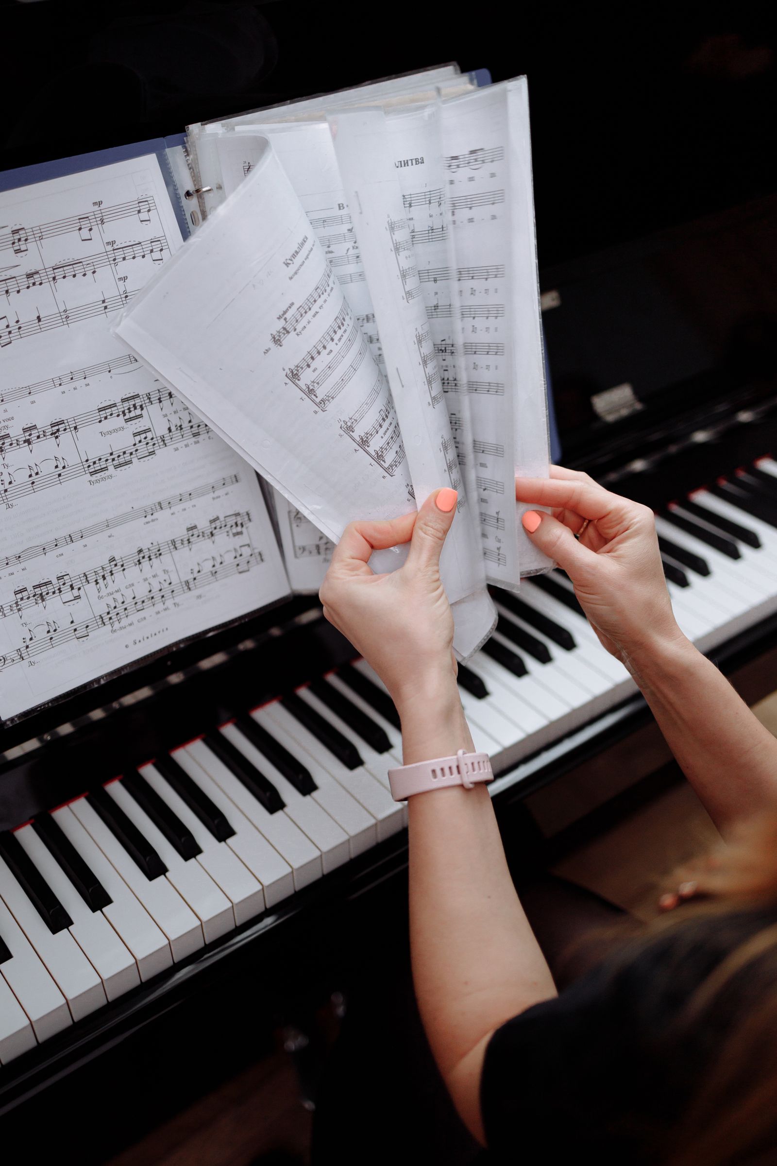 Mains tournant des partitions posées sur un piano