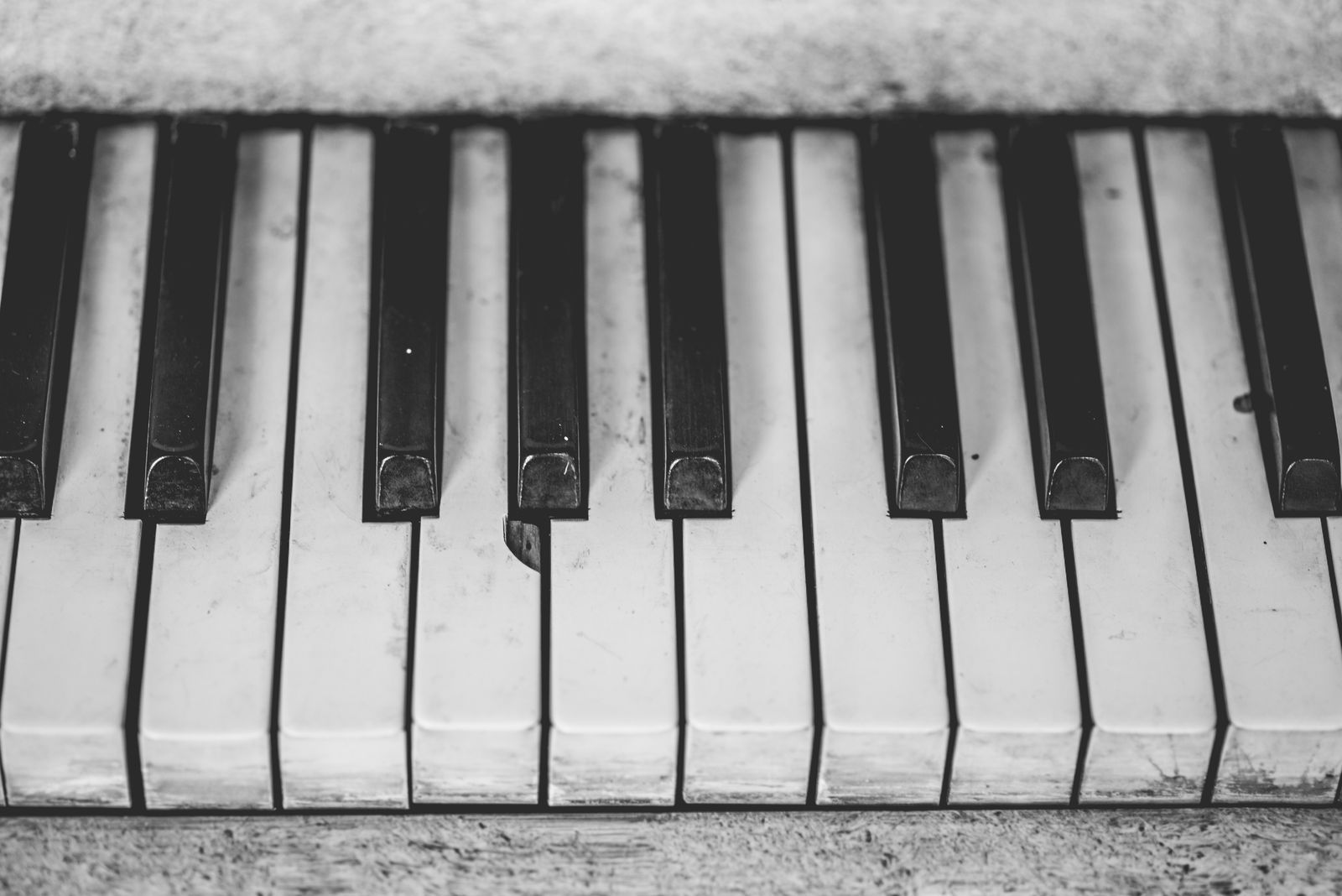 Gros plan en noir et blanc sur des touches de piano, illustrant la protection du clavier contre la poussière et les rayures