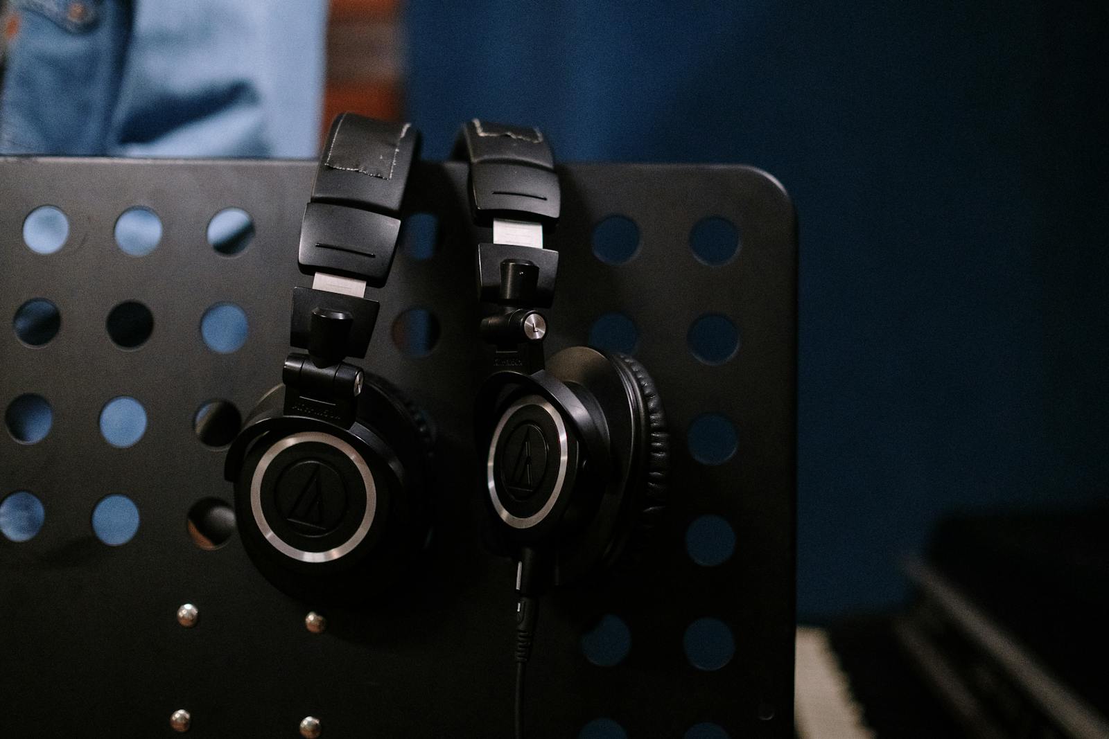 Deux casques audio posés sur un pupitre devant un piano