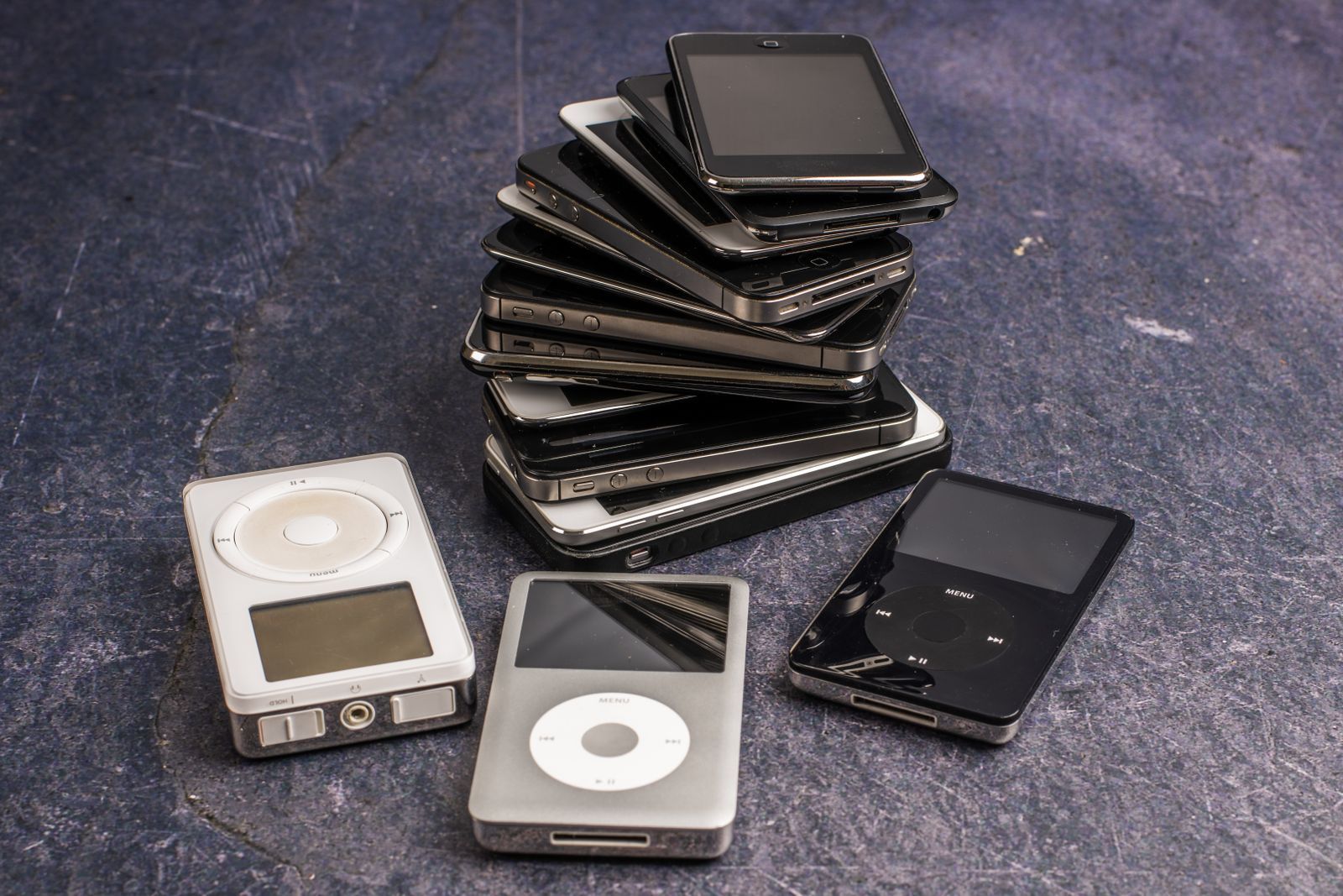 Pile de vieux lecteurs MP3 et smartphones usagés, illustrant le vieillissement des appareils électroniques
