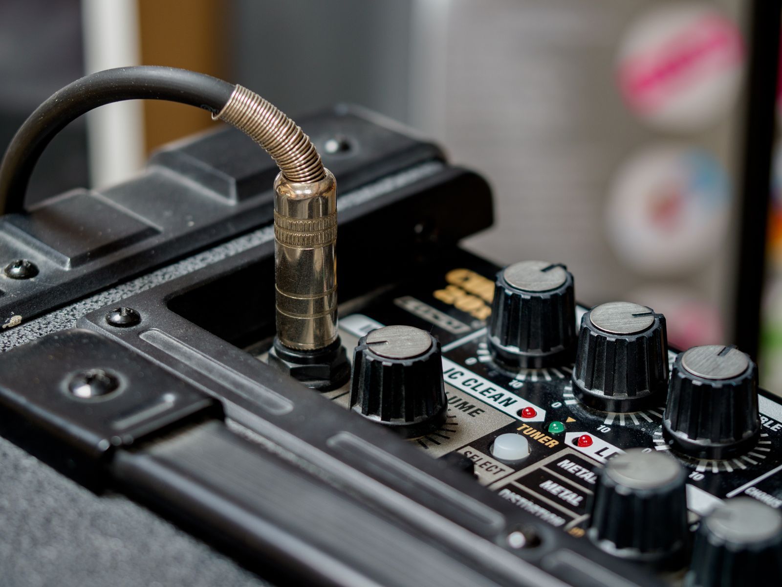 Câble jack branché dans un amplificateur avec ses potentiomètres