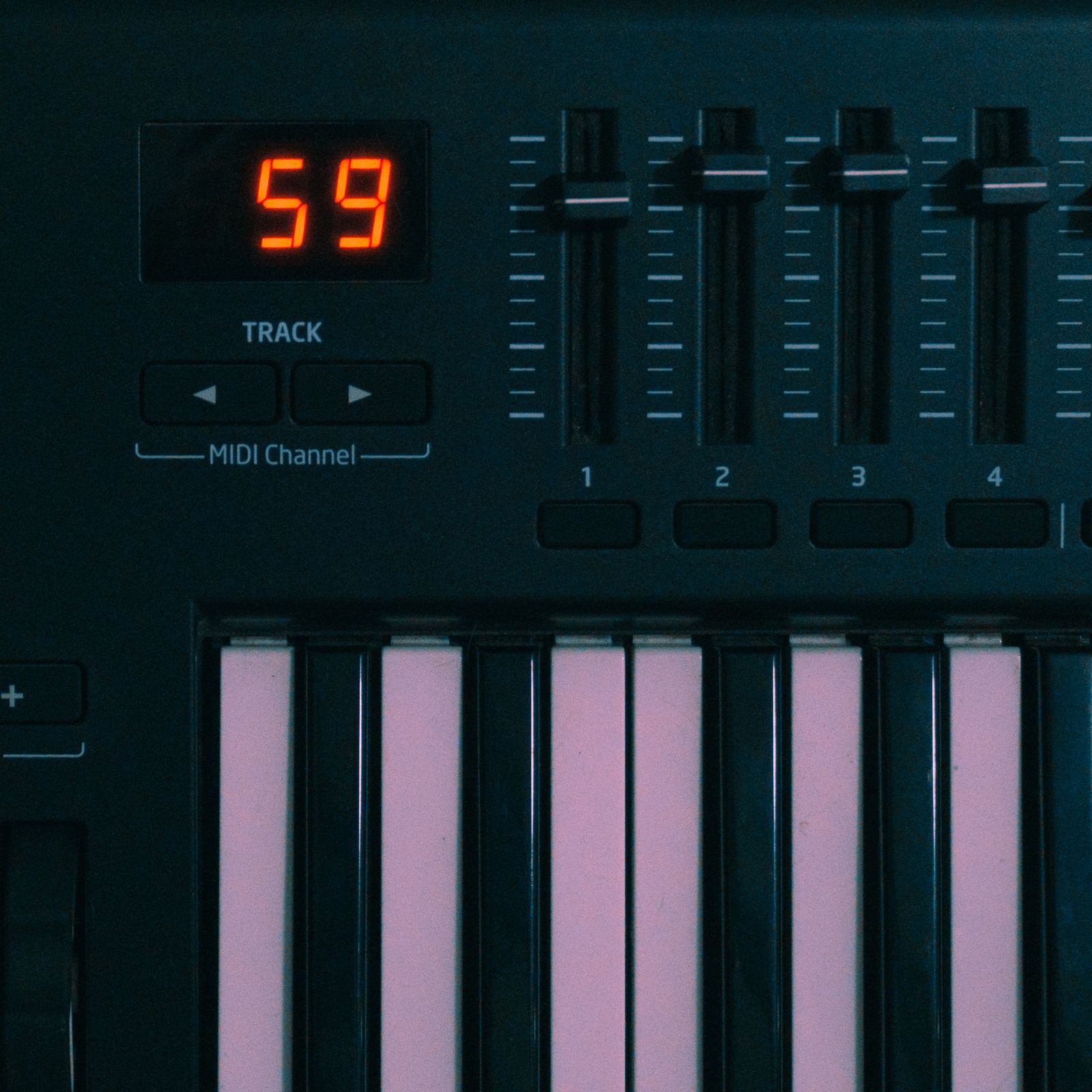 Gros plan sur les touches d'un clavier MIDI avec un afficheur indiquant le canal, touches roses et noires