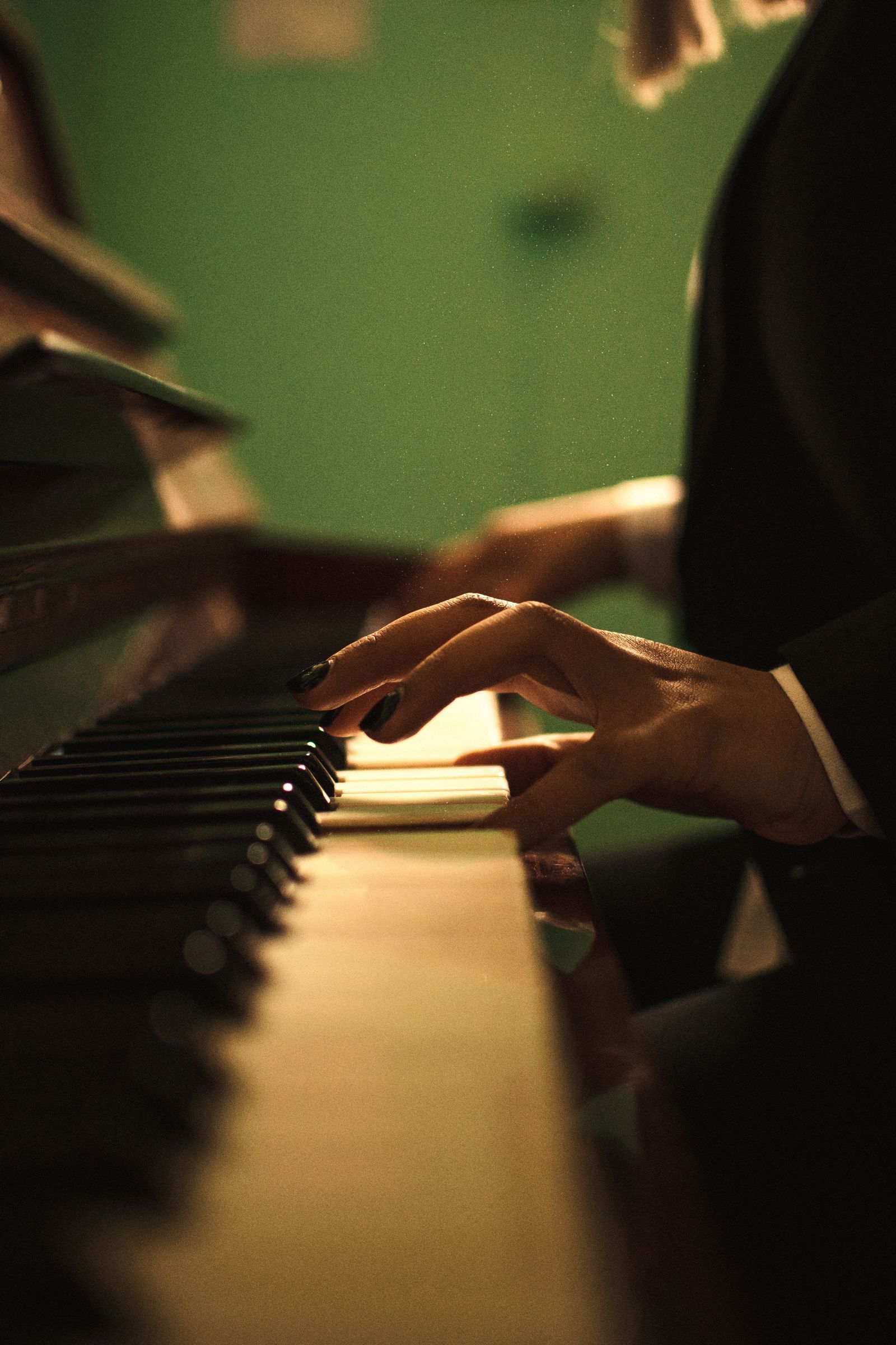 Gros plan sur une main jouant les touches d'un piano dans une ambiance chaleureuse