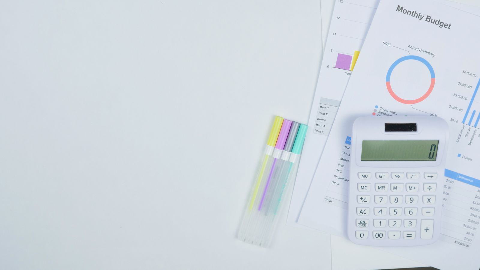 Calculatrice et budget mensuel posés sur un bureau