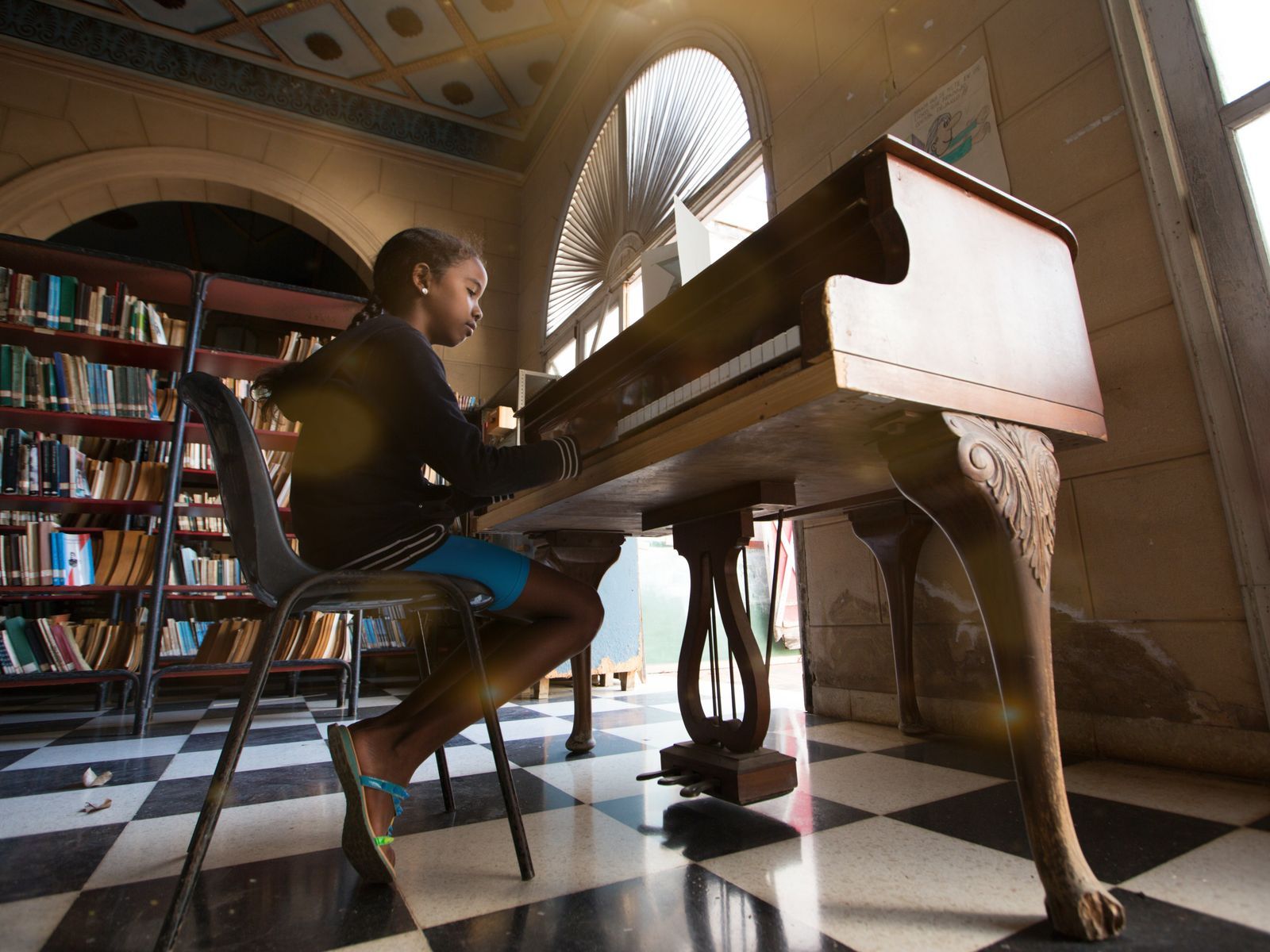 Jeune pianiste jouant sur un piano dans une pièce lumineuse