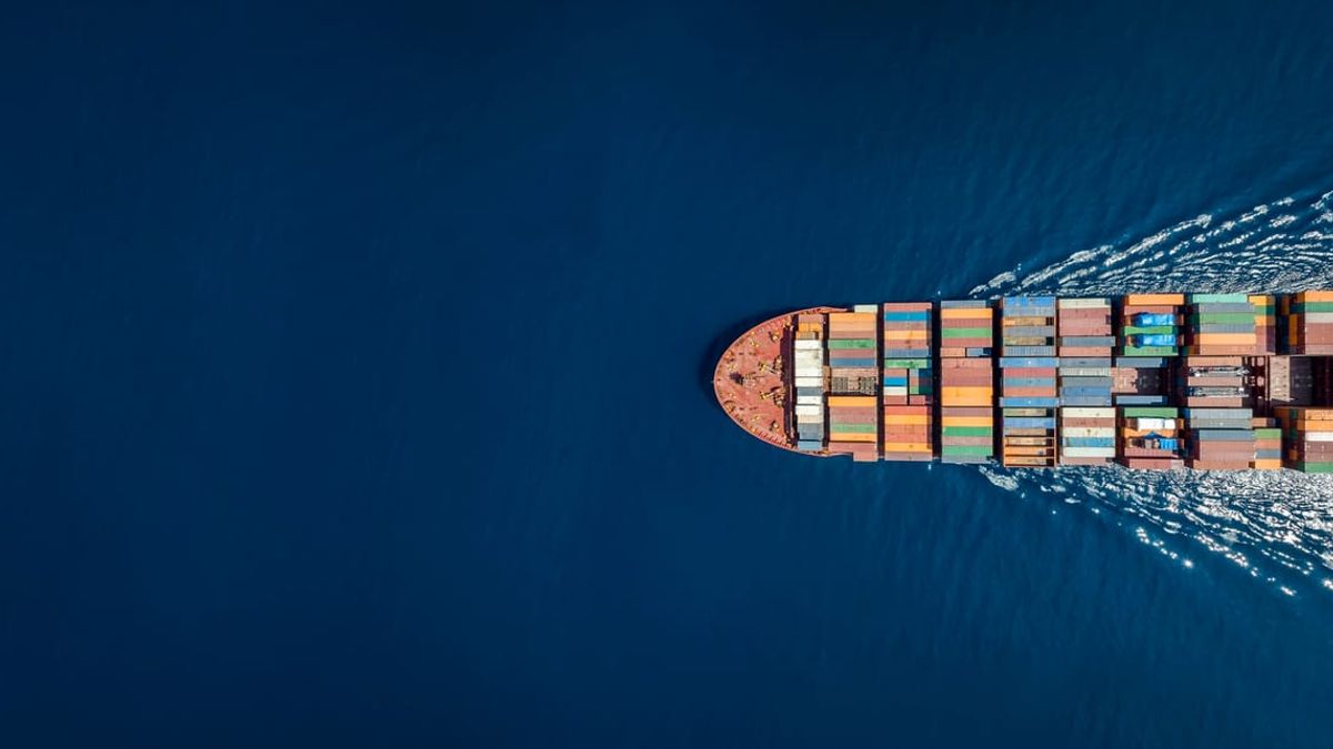 A container ship carrying freight across open ocean, seen from above