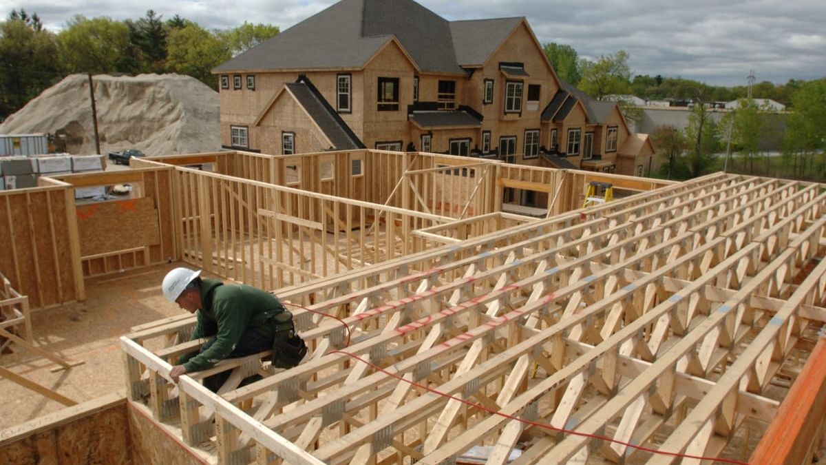 A carpenter working on the timber frame of a house under construction
