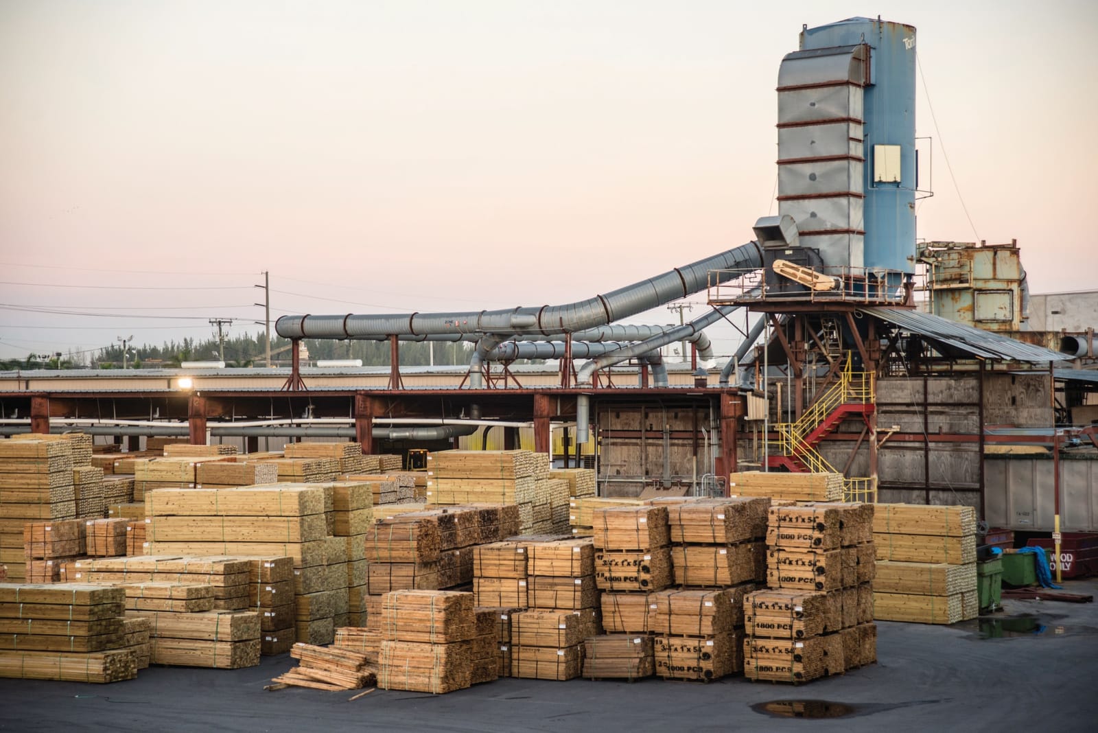 A lumber processing yard at dusk