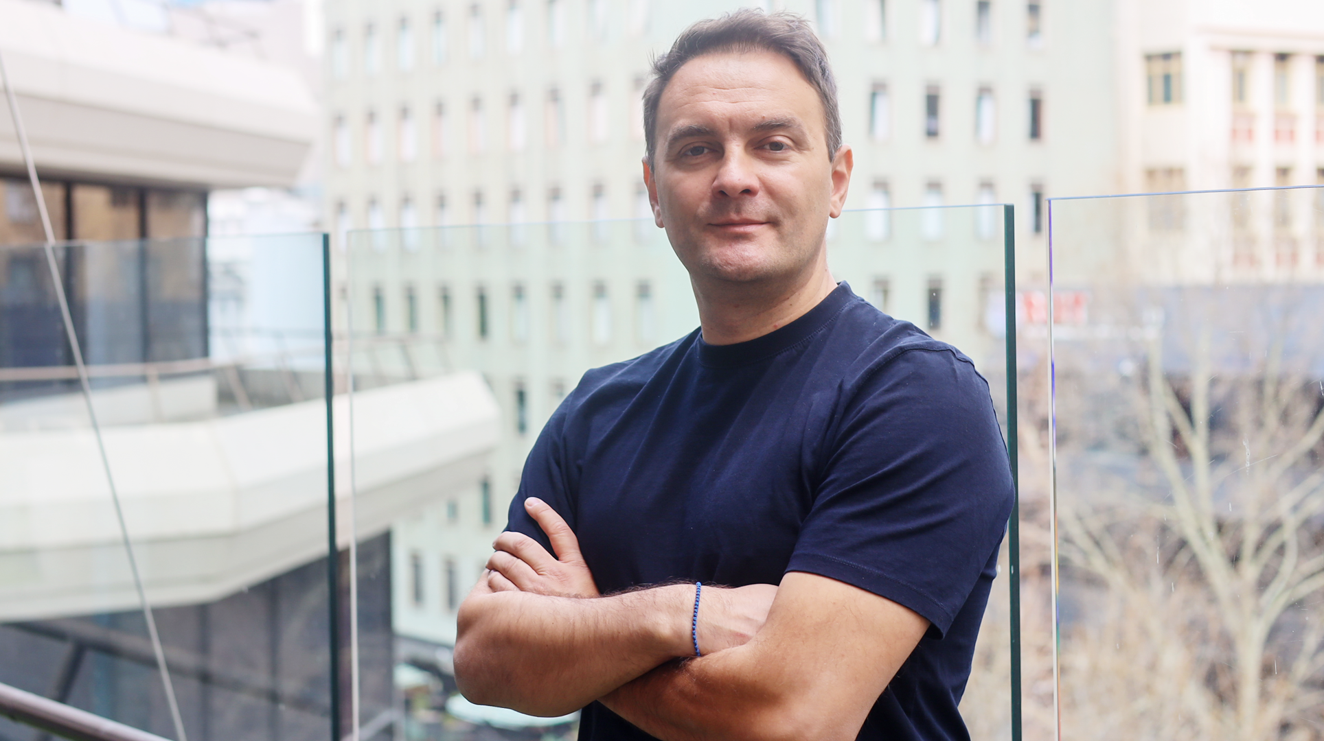 Portrait photograph of Andrej Luneski on balcony
