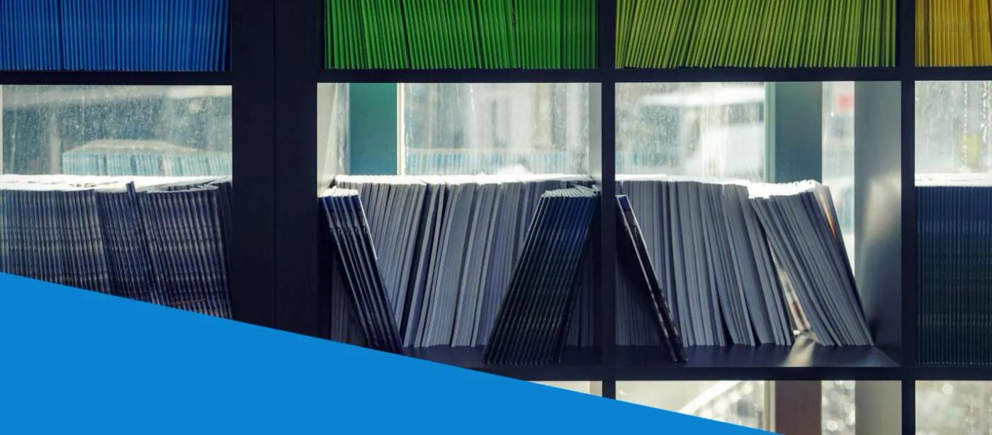 Shelves hold rows of paper folders beside a window.