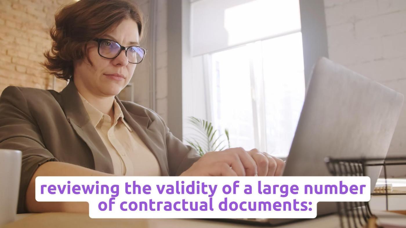 A reviewer reads a paper document beside a laptop, with source text about contract review.