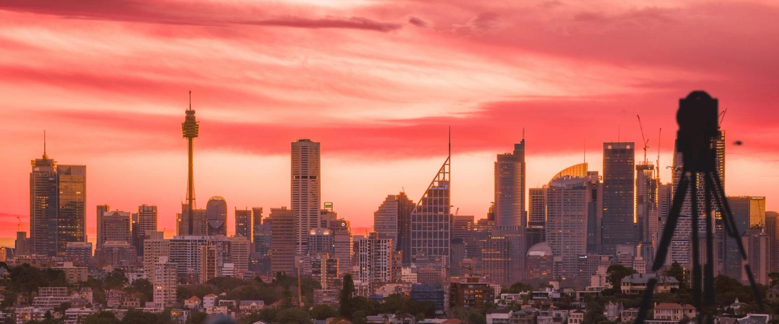 Sydney city skyline at sunset with a survey instrument in the foreground