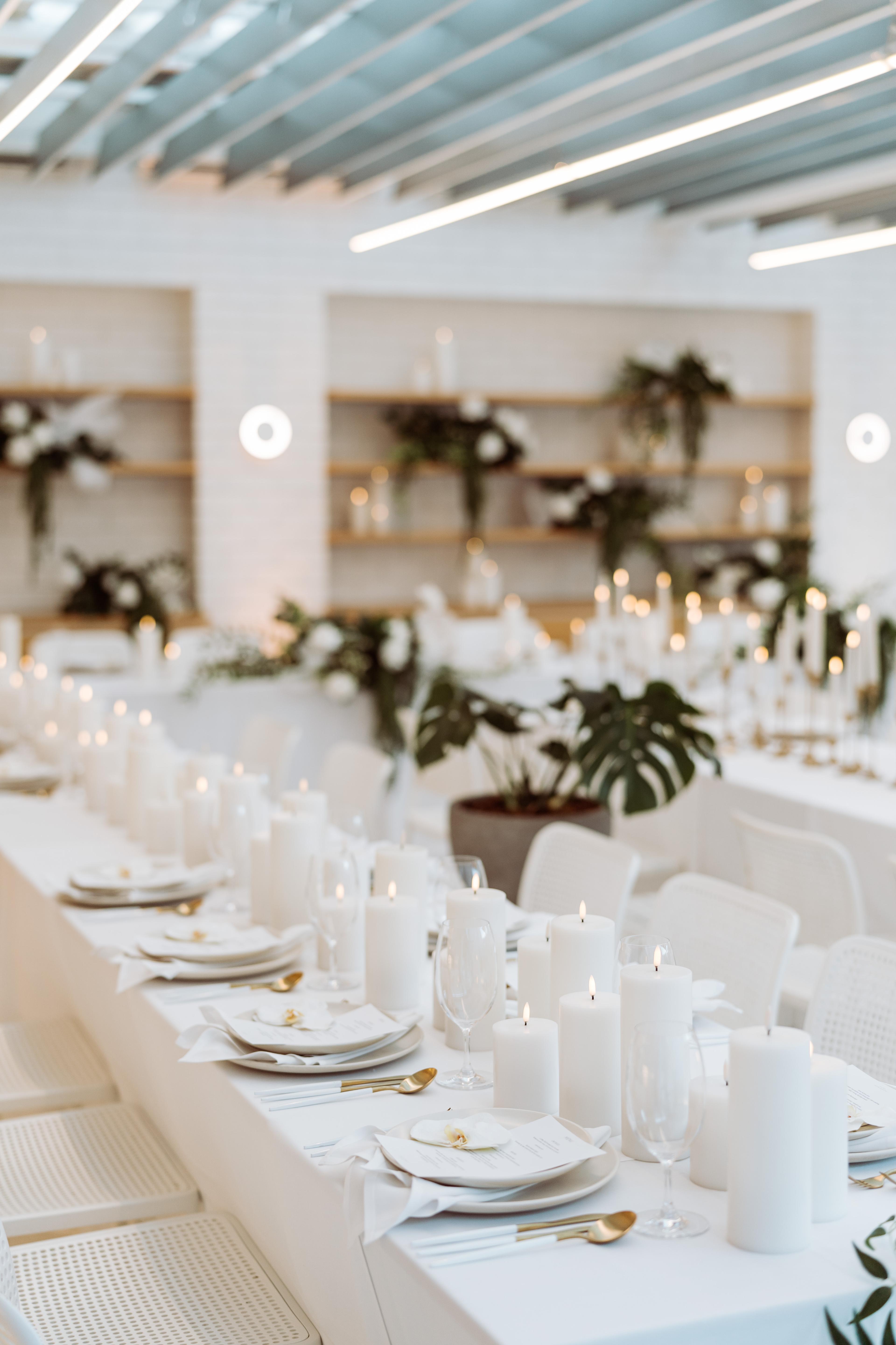 Minimal white tablescape at Industry Beans Newstead in Brisbane, styled with candles, white place settings, soft florals and modern event details.