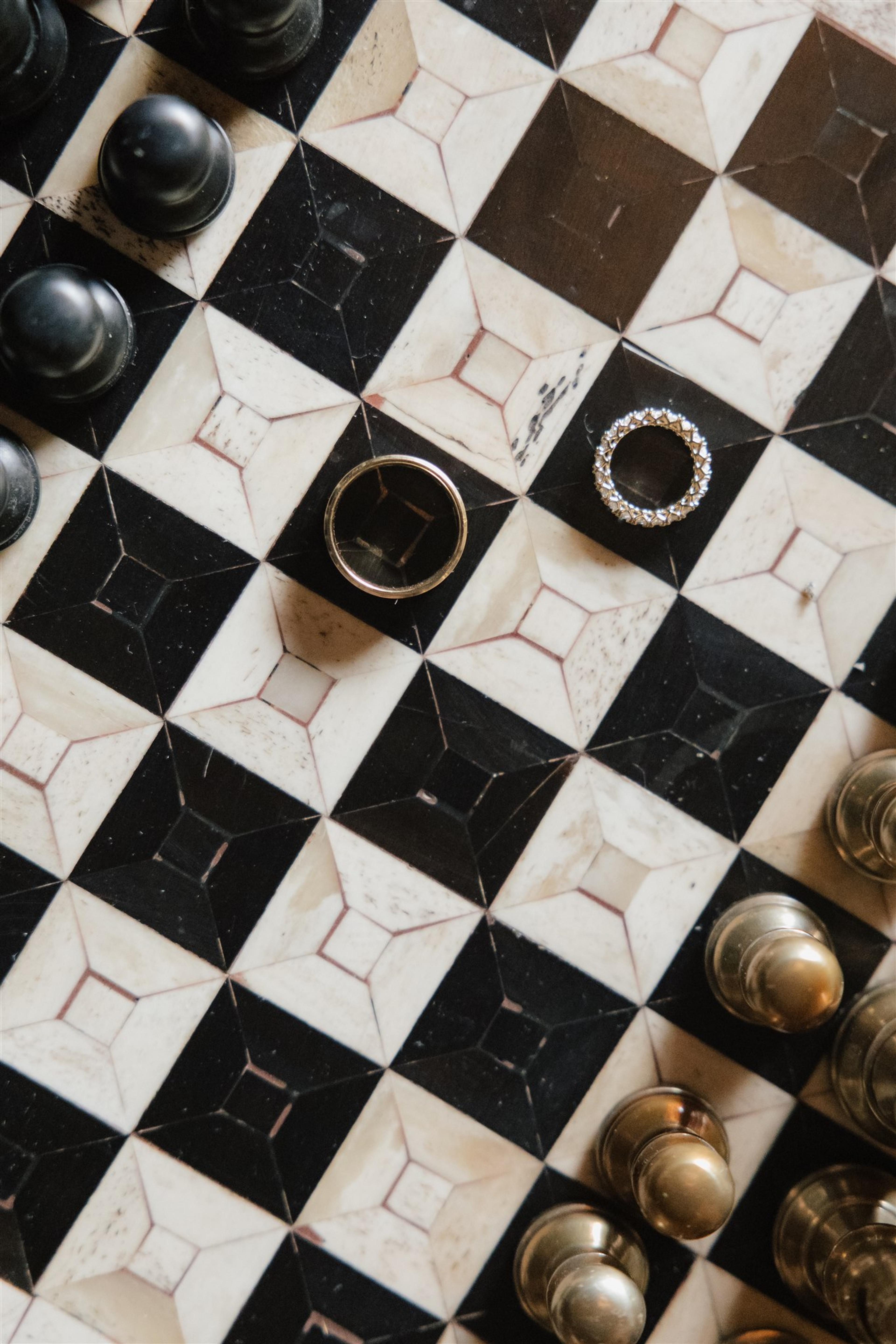 Wedding rings styled on a black and white chessboard at The Valley Estate Gold Coast wedding for Rochelle and Jeff.